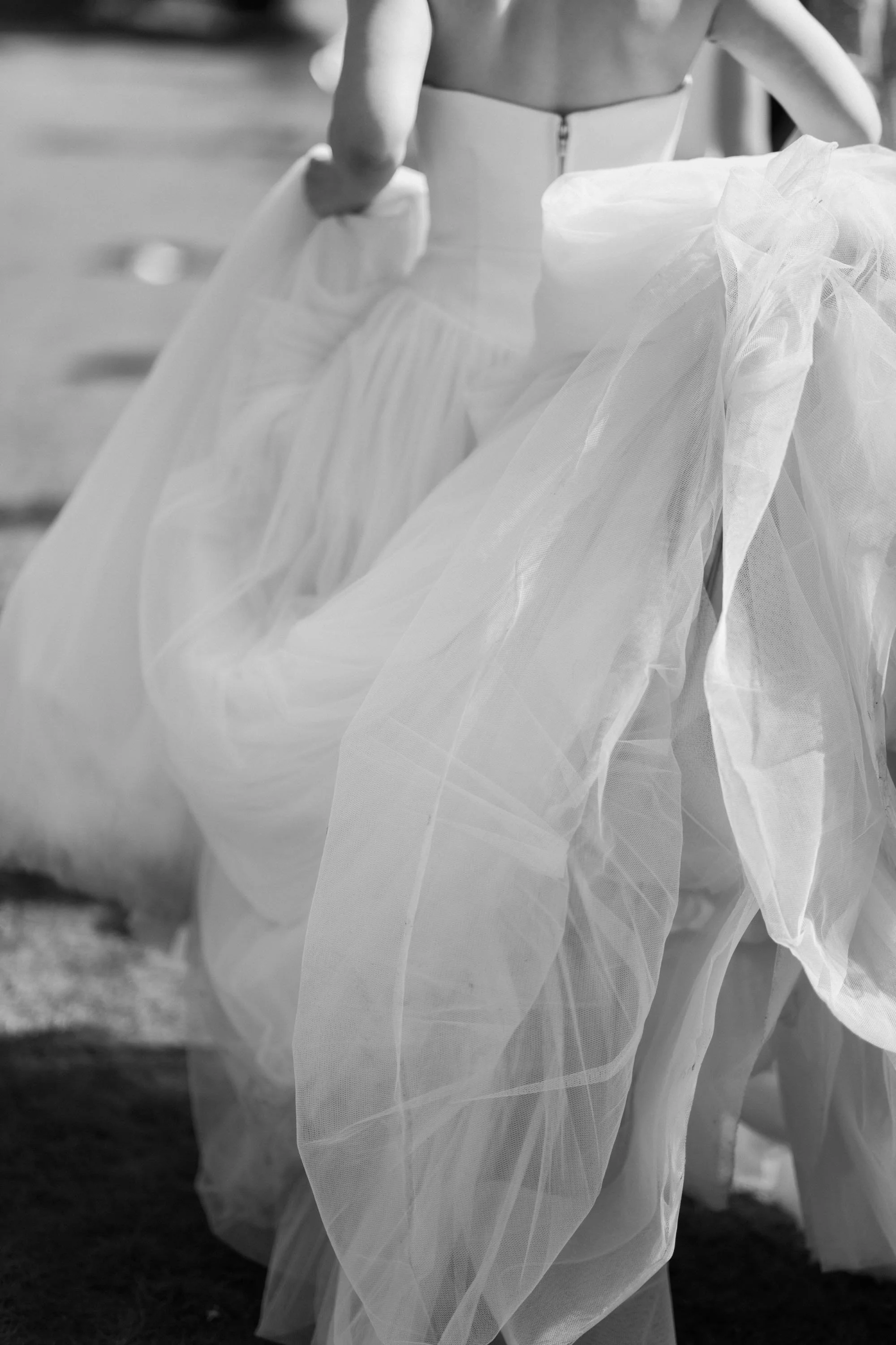 Bride holding her wedding dress as she walks after the ceremony.