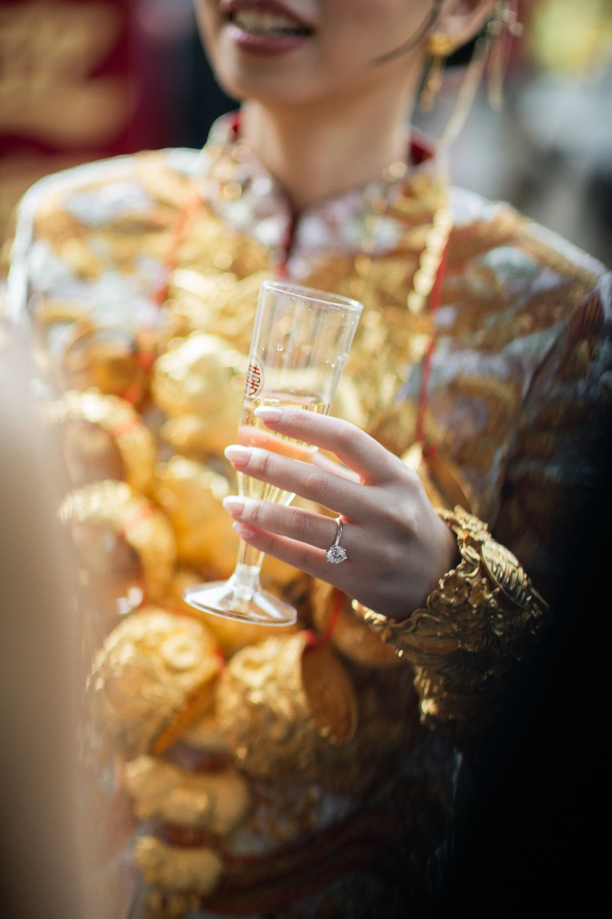 Bride holding a glass of champagne after the tea ceremony.