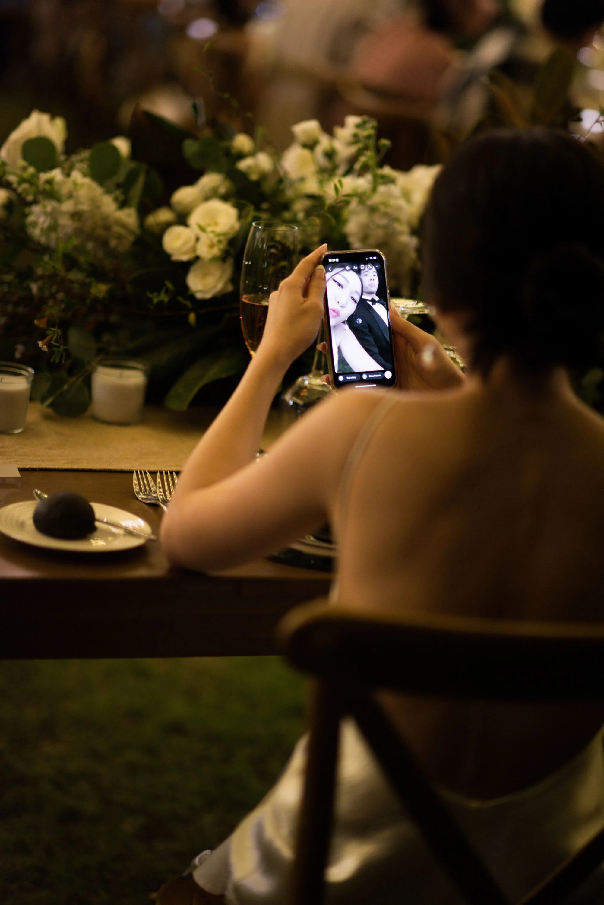 Bride taking a playful selfie with the groom during dinner.