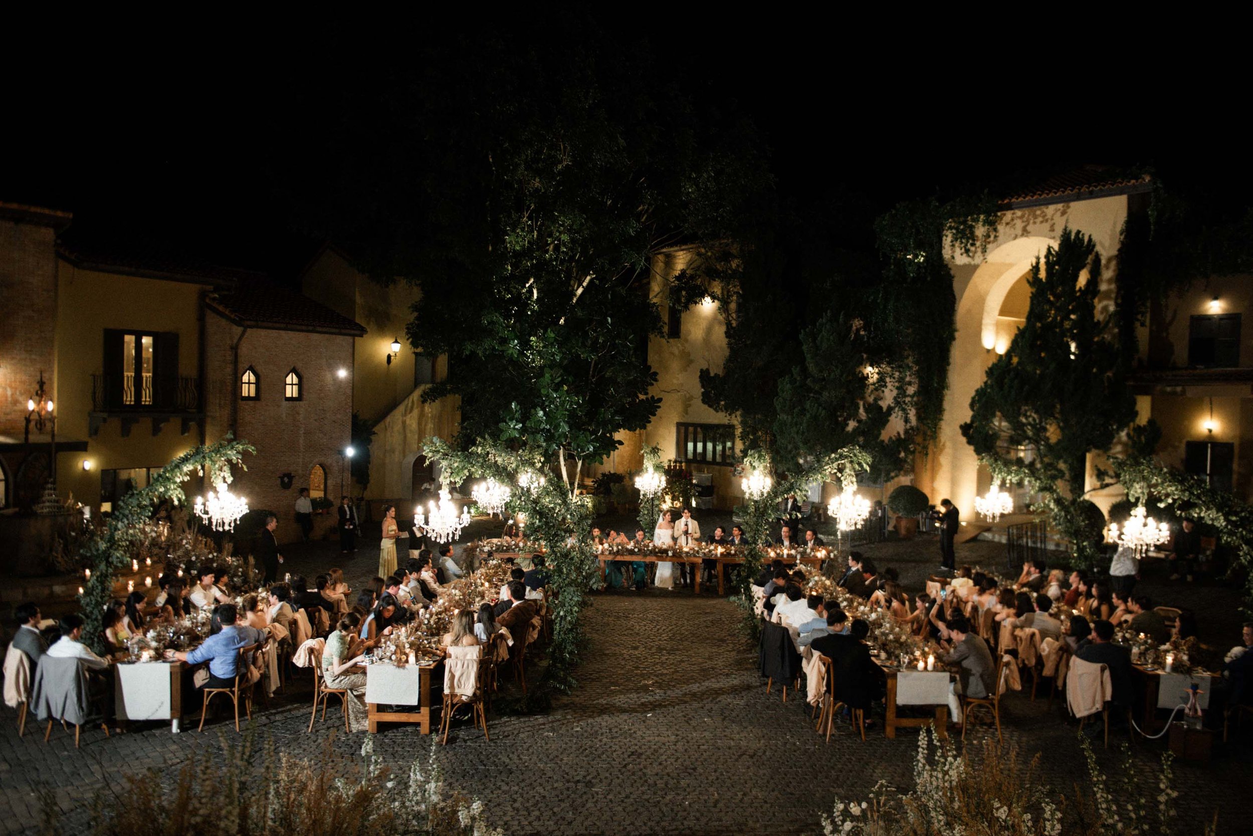 Bride and groom thanking their guests from their table during dinner.
