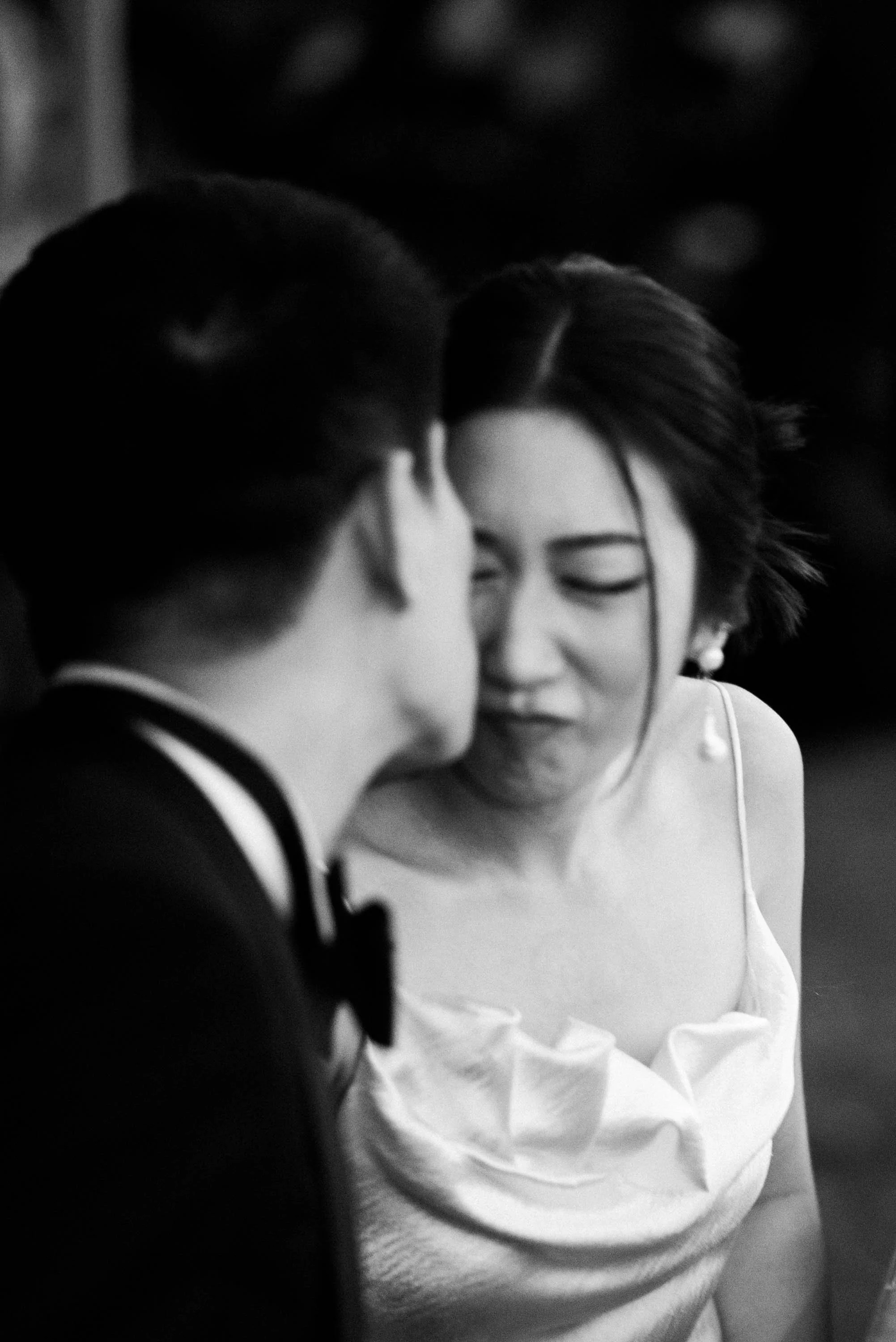 Groom kissing the bride on the cheek as she makes a playful expression.