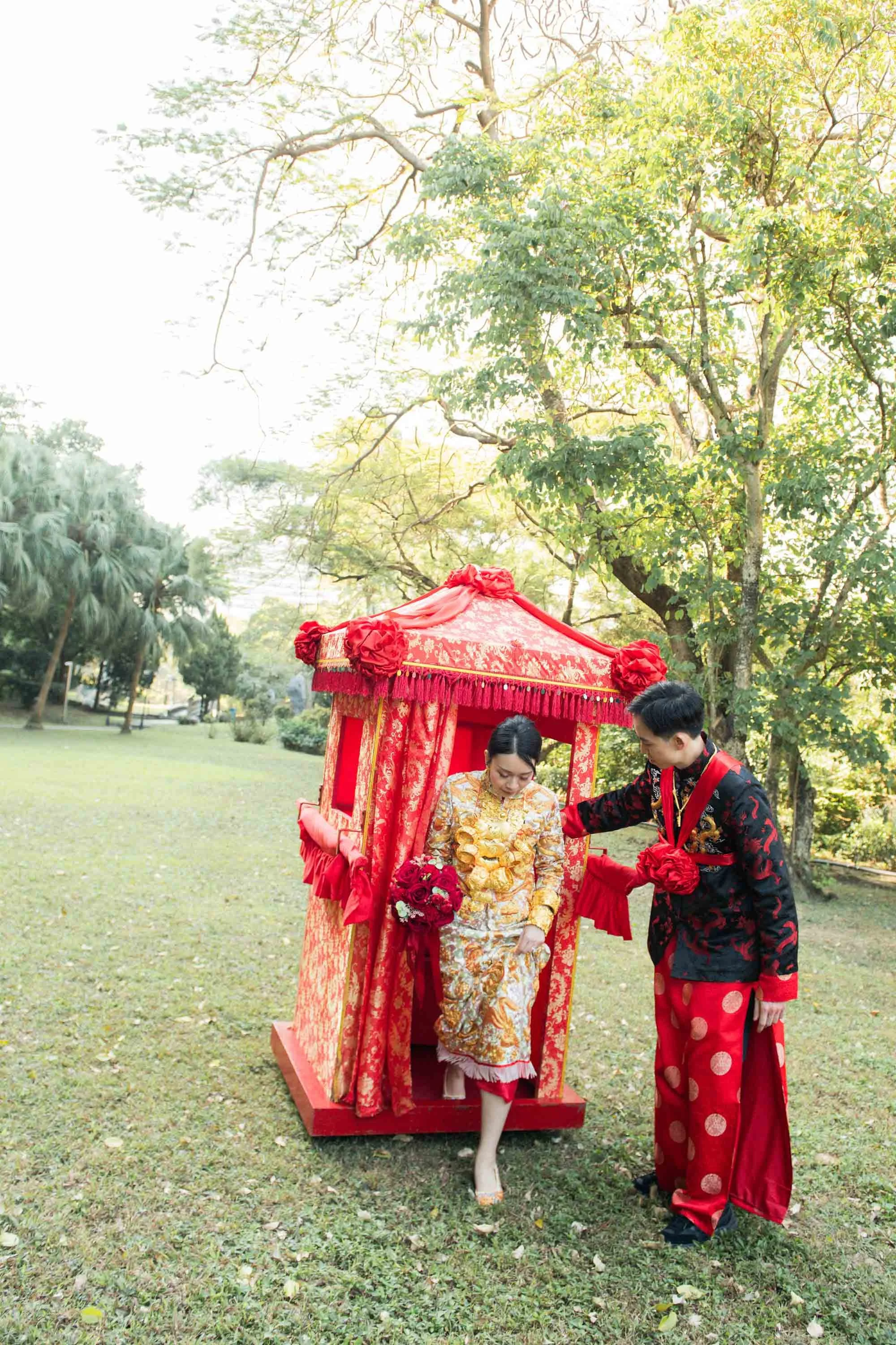 Groom helping the bride step out of the bridal sedan chair.