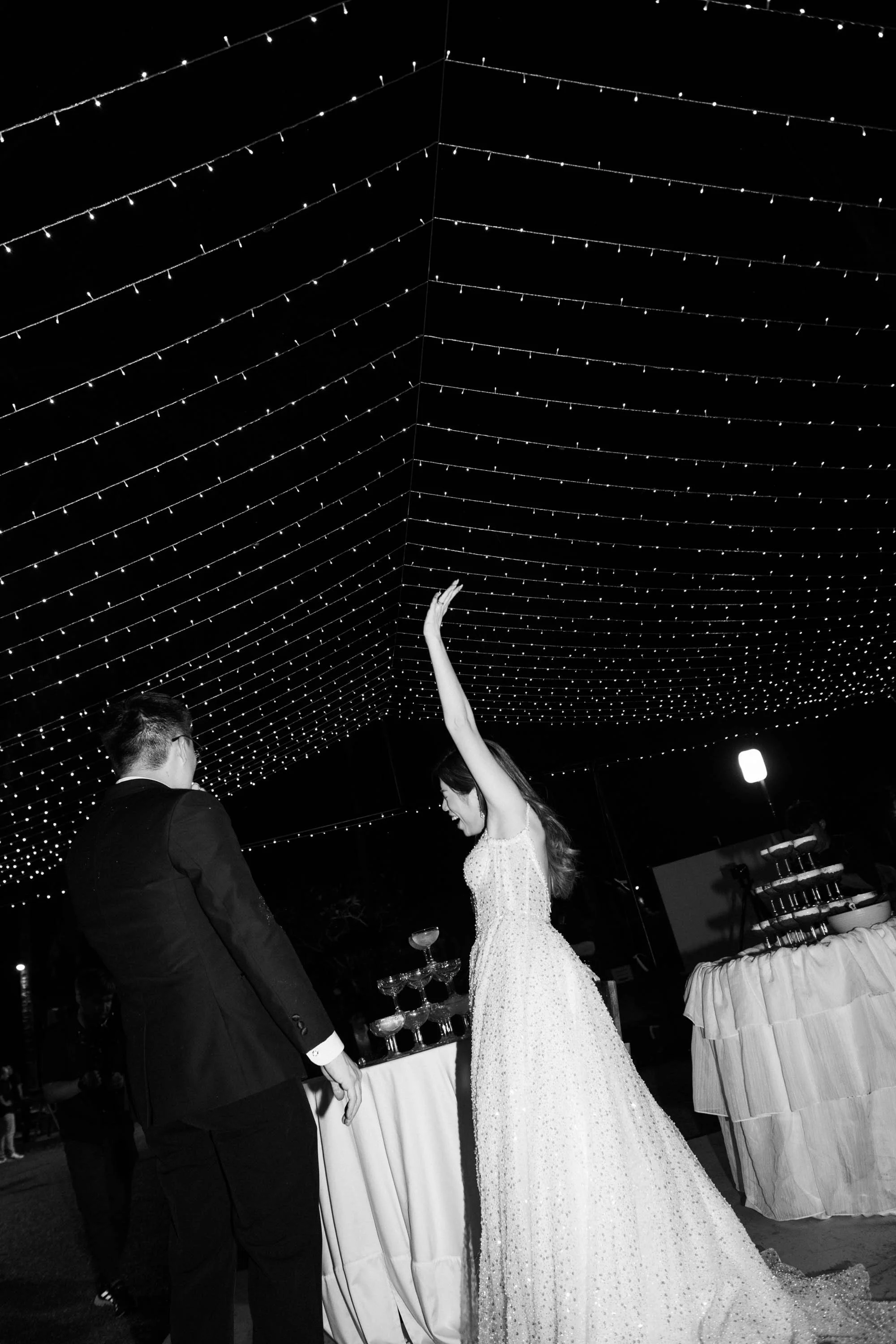 Bride and groom celebrating after pouring the champagne tower.