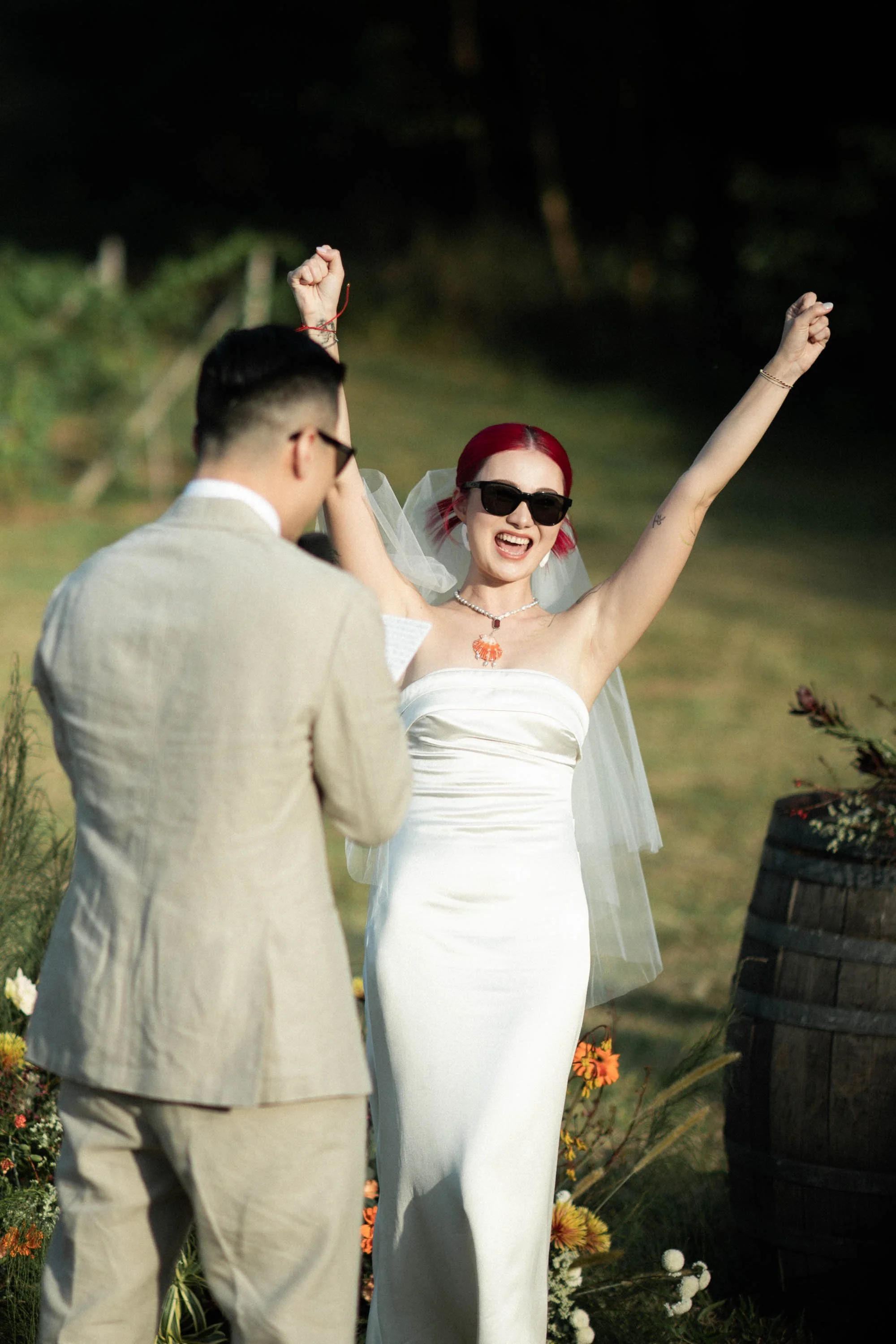 Bride raising her hand to celebrate with guests during the ceremony.