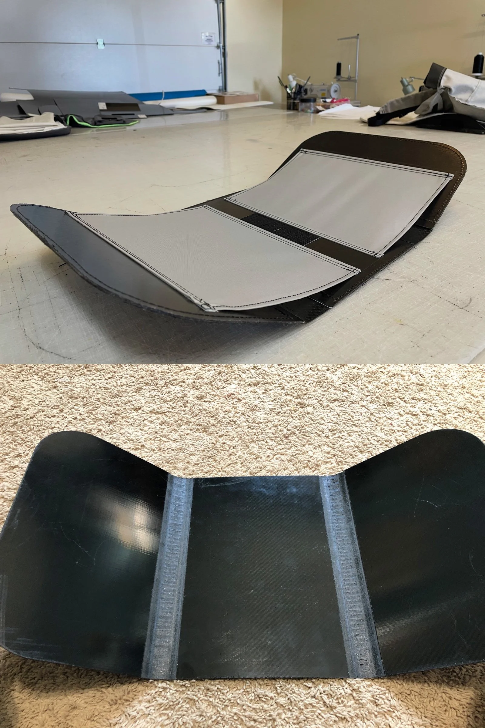 A black skateboard deck with grip tape, lying on a beige carpeted floor, with parts of the object taking on a curved shape.