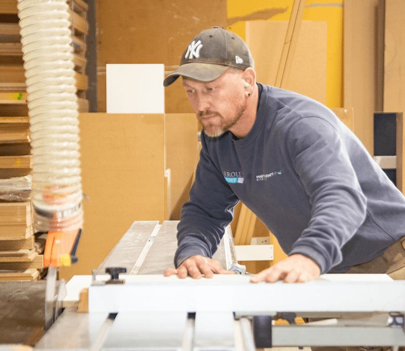 Carrolls cabinetmaker working with machinery in the cabinetry workshop.