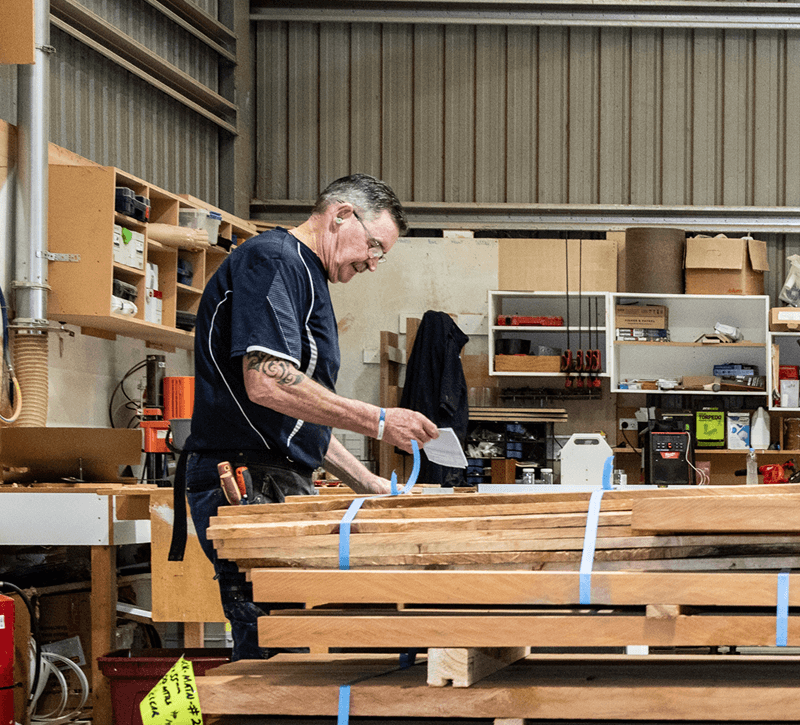 Carrolls timber joiner working with solid timber in the Masterton workshop.