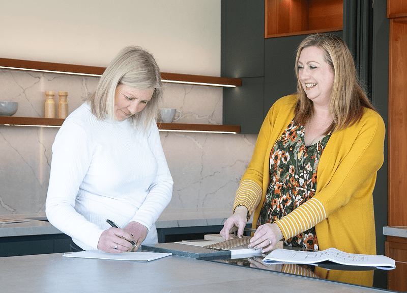 Two Carrolls designers reviewing plans and material samples in the Masterton showroom.