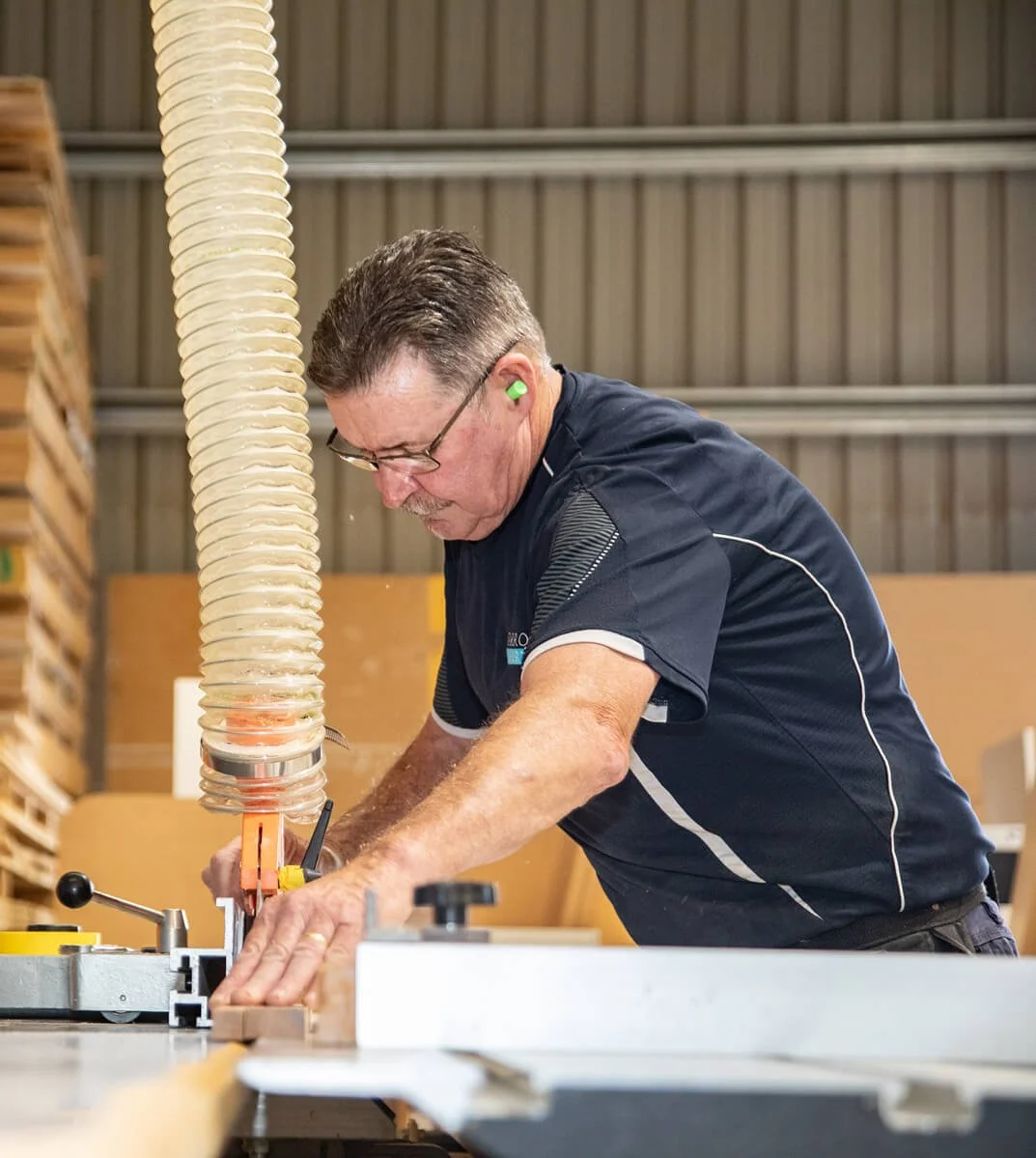 Carrolls joiner working with machinery in the Masterton workshop.