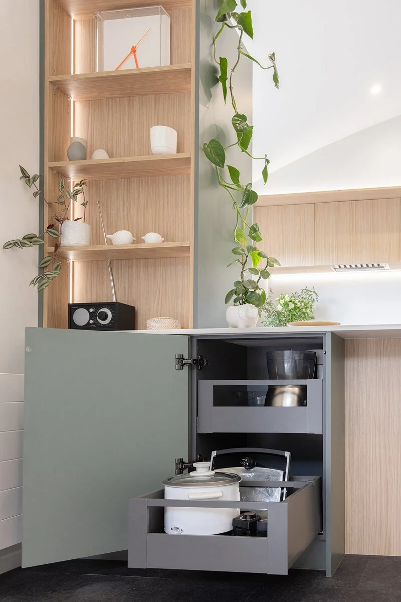 Bespoke kitchen storage with pull-out drawers for pots and cookware.