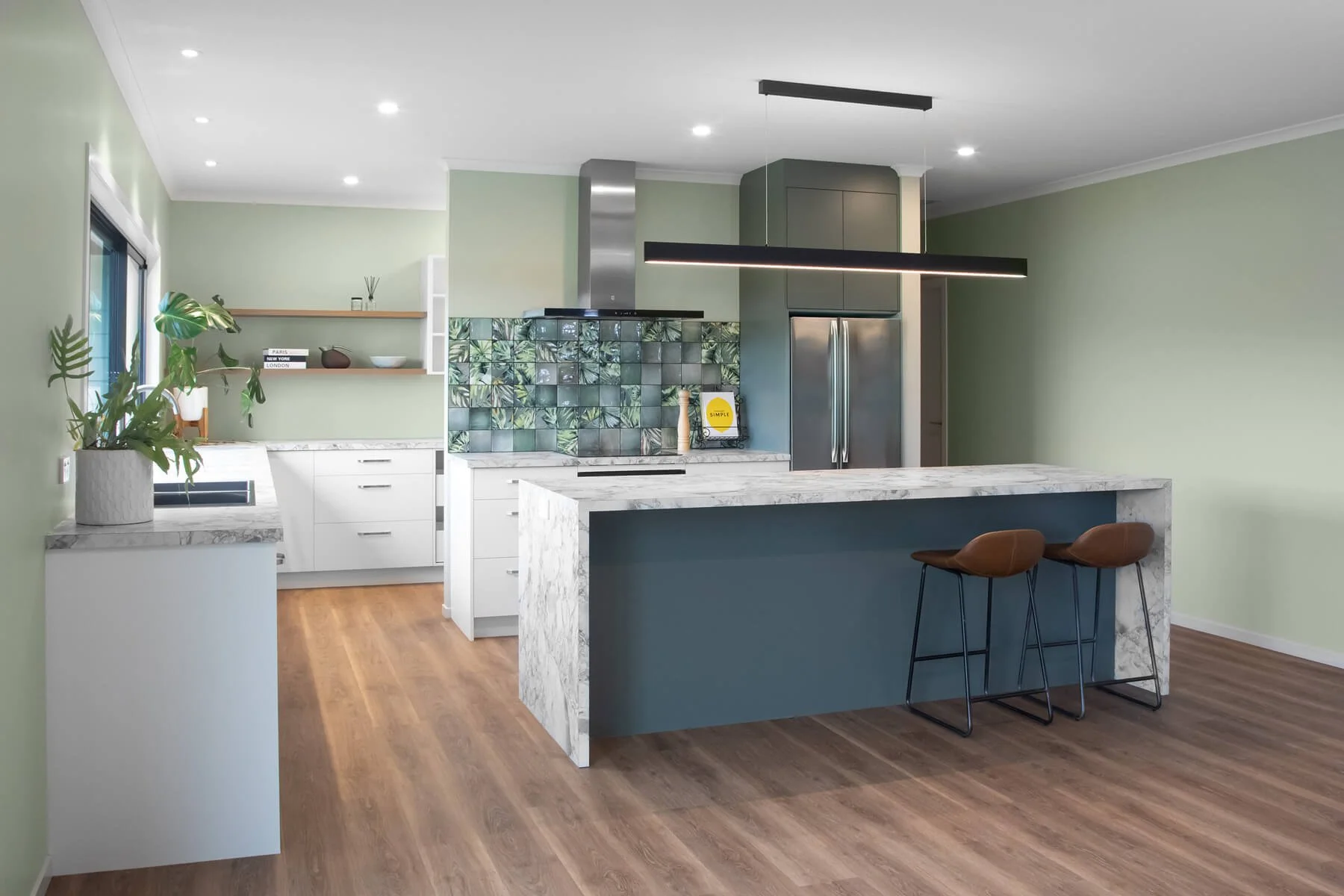 Contemporary kitchen with marble-look laminate benchtops, green cabinetry and botanical tiled splashback.