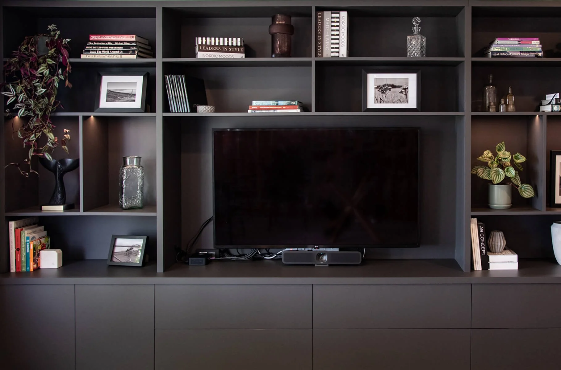 Built-in media cabinetry with shelving and integrated television.