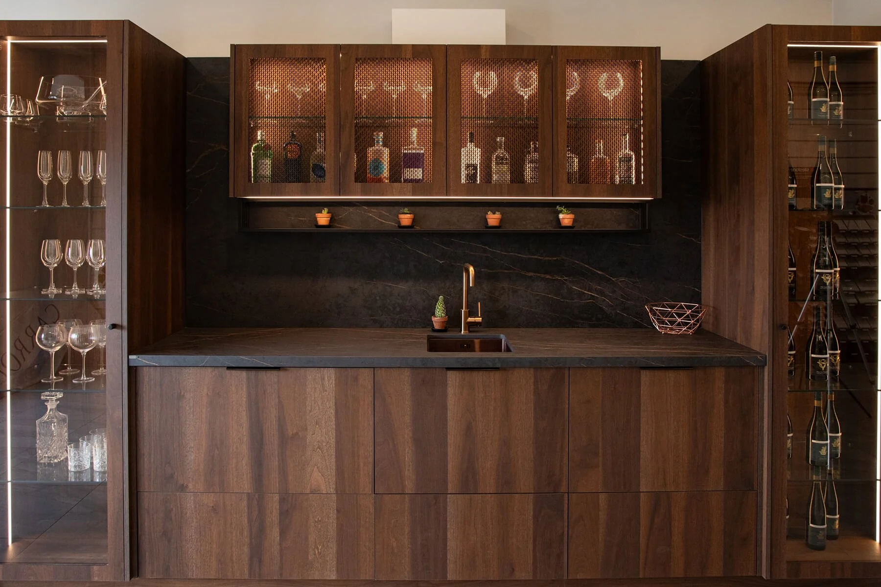 Bespoke timber bar cabinetry with dark stone benchtop and glazed storage.