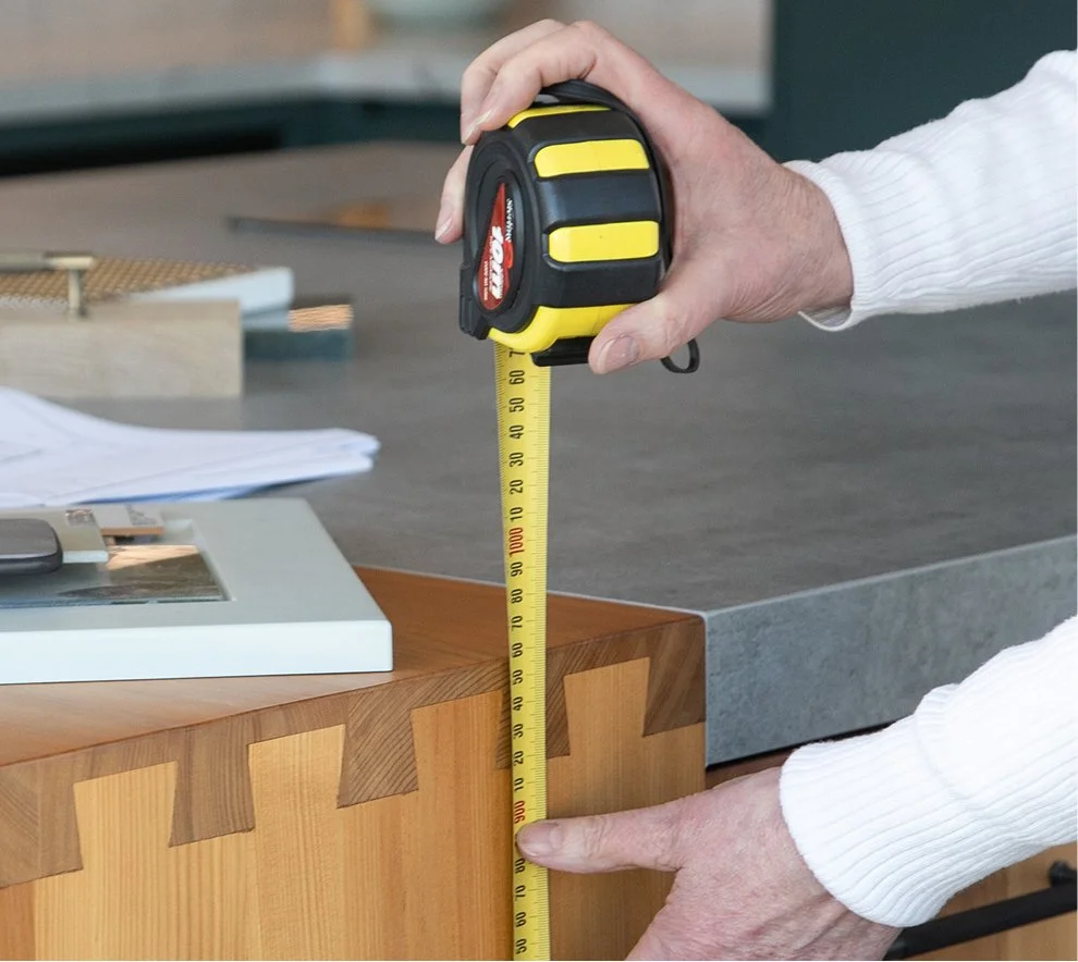 Measuring the timber and stone detailing of a kitchen island.