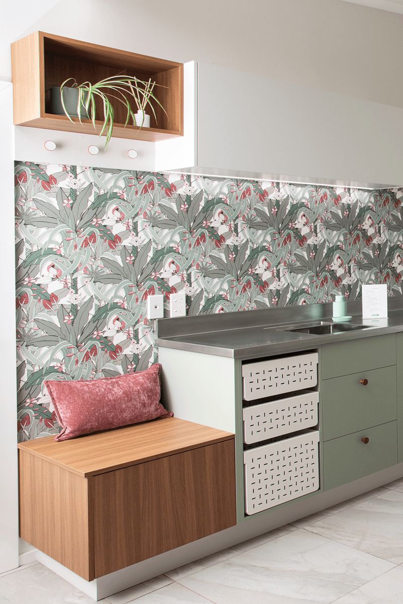 Bespoke laundry with sage green cabinetry, timber bench seat and concealed storage.