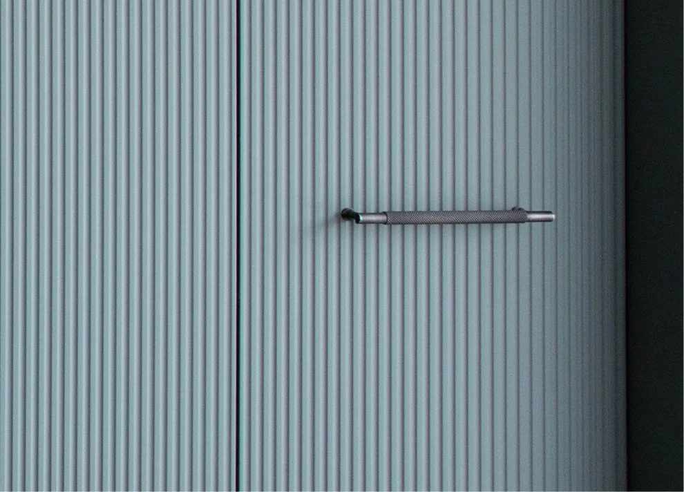 Close-up of fluted cabinetry with a dark metal handle.