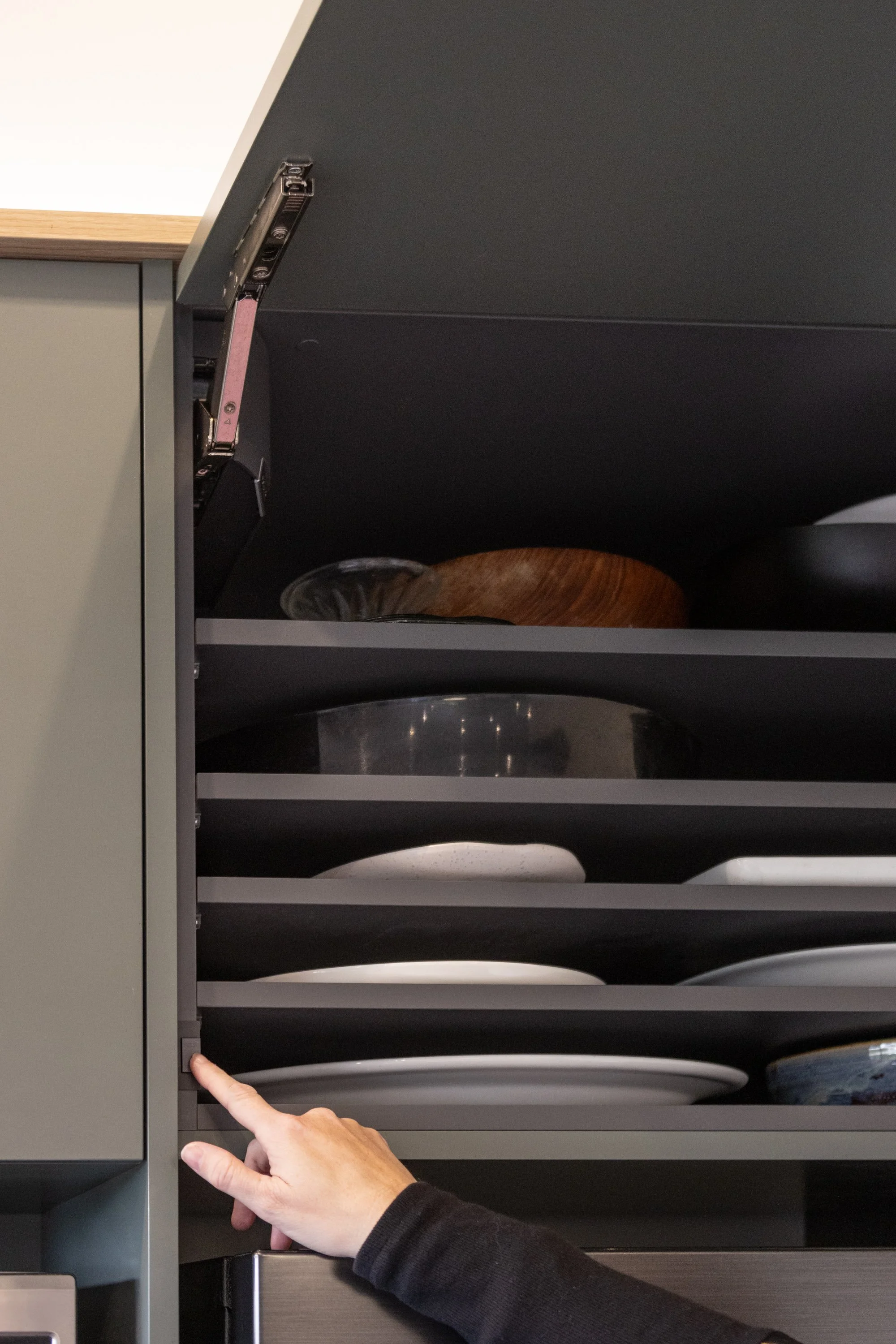 Interior storage for plates and bowls inside a kitchen cabinet.