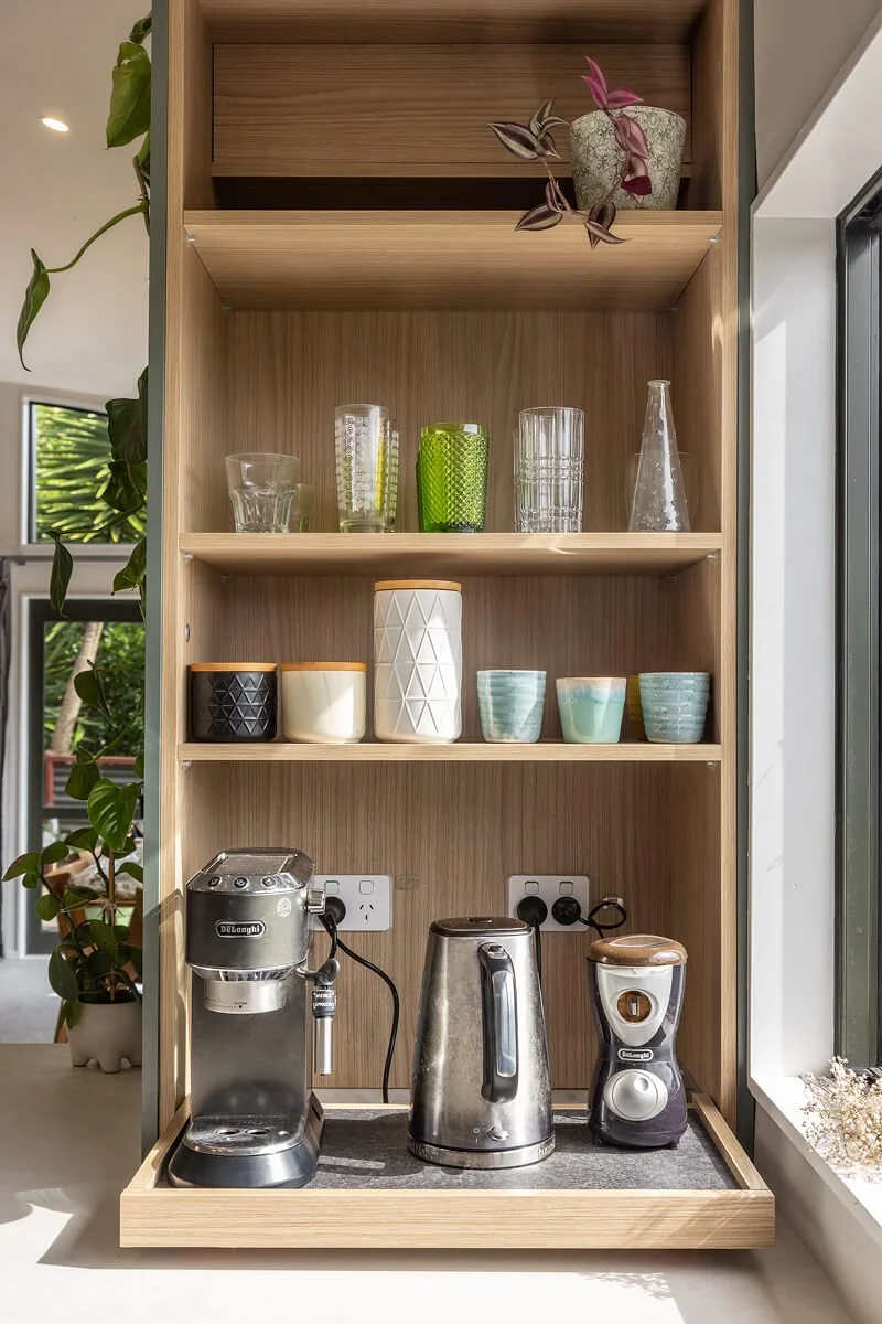 Built-in coffee station with timber shelving and storage for cups and appliances.