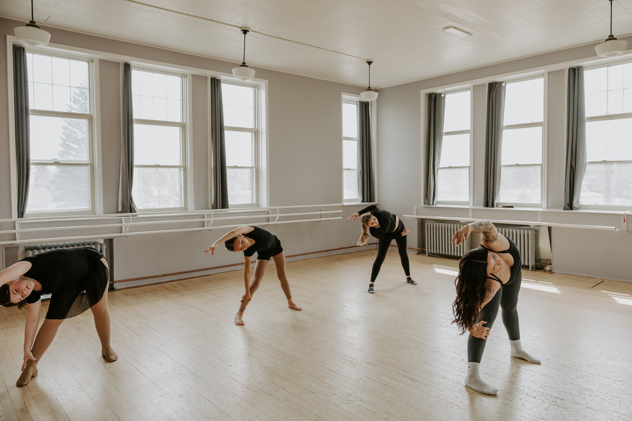 Dancers stretching in a warm-up lead by dance pilates specialist