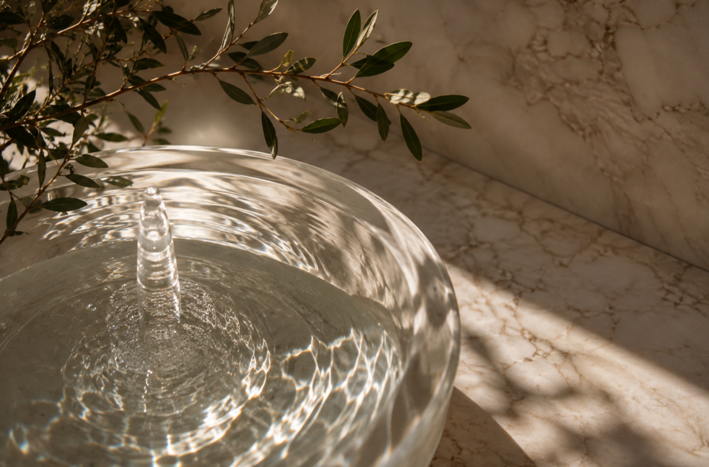 Sunlit water ripples with natural botanical details.
