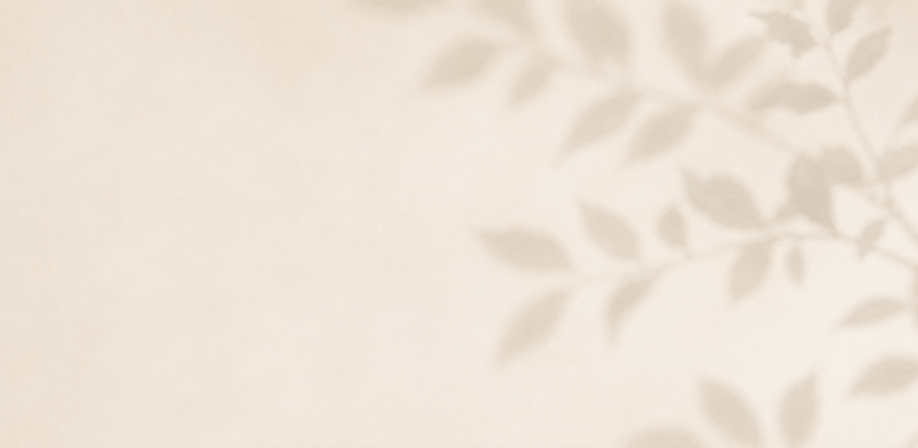 Blurred image of shadows of leaves on a beige background.