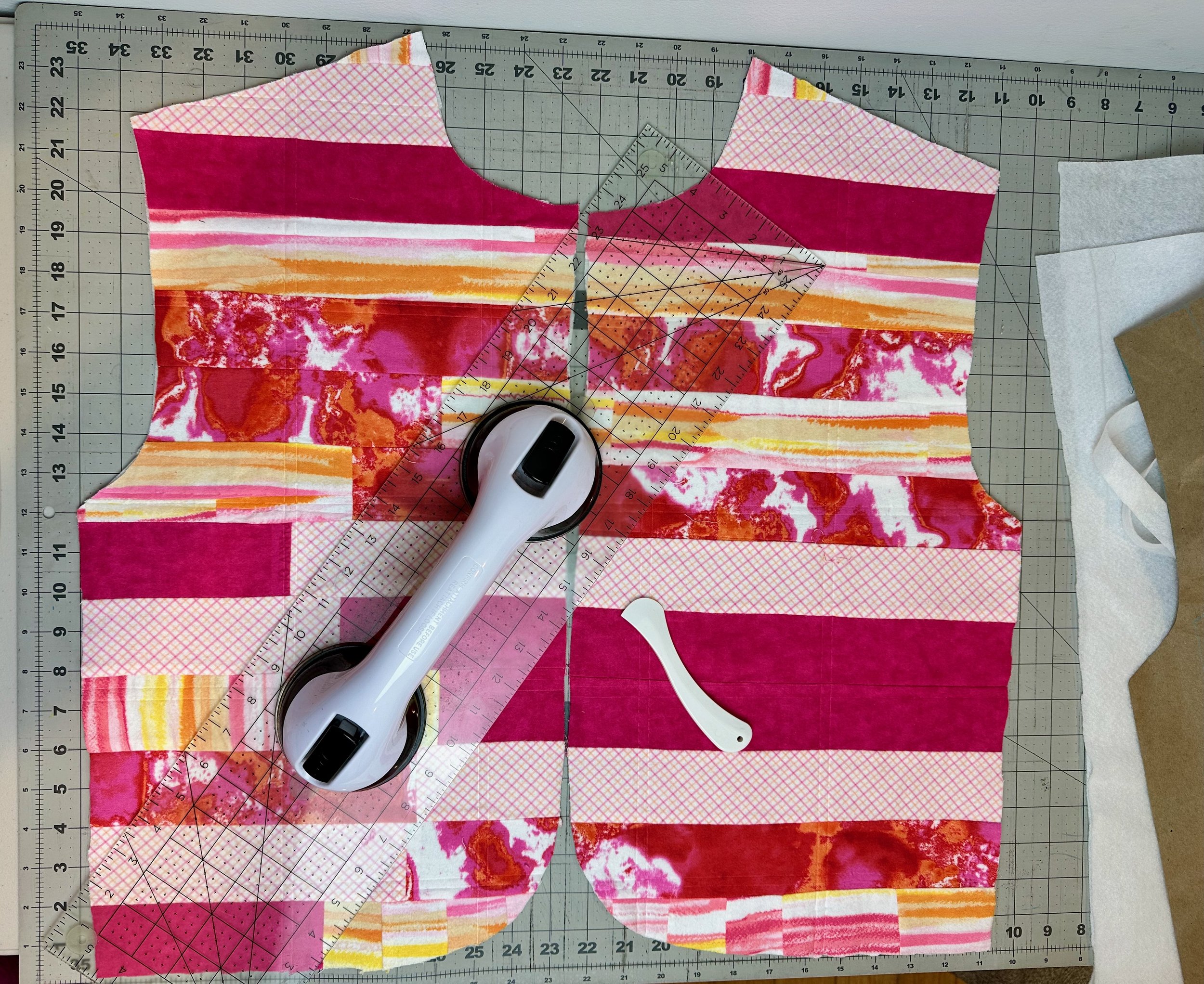 Colorful fabric pieces and quilting tools 
including a rotary cutter and cutting mat 
in the Nicollet's Place handmade studio 
in Altadena, California.