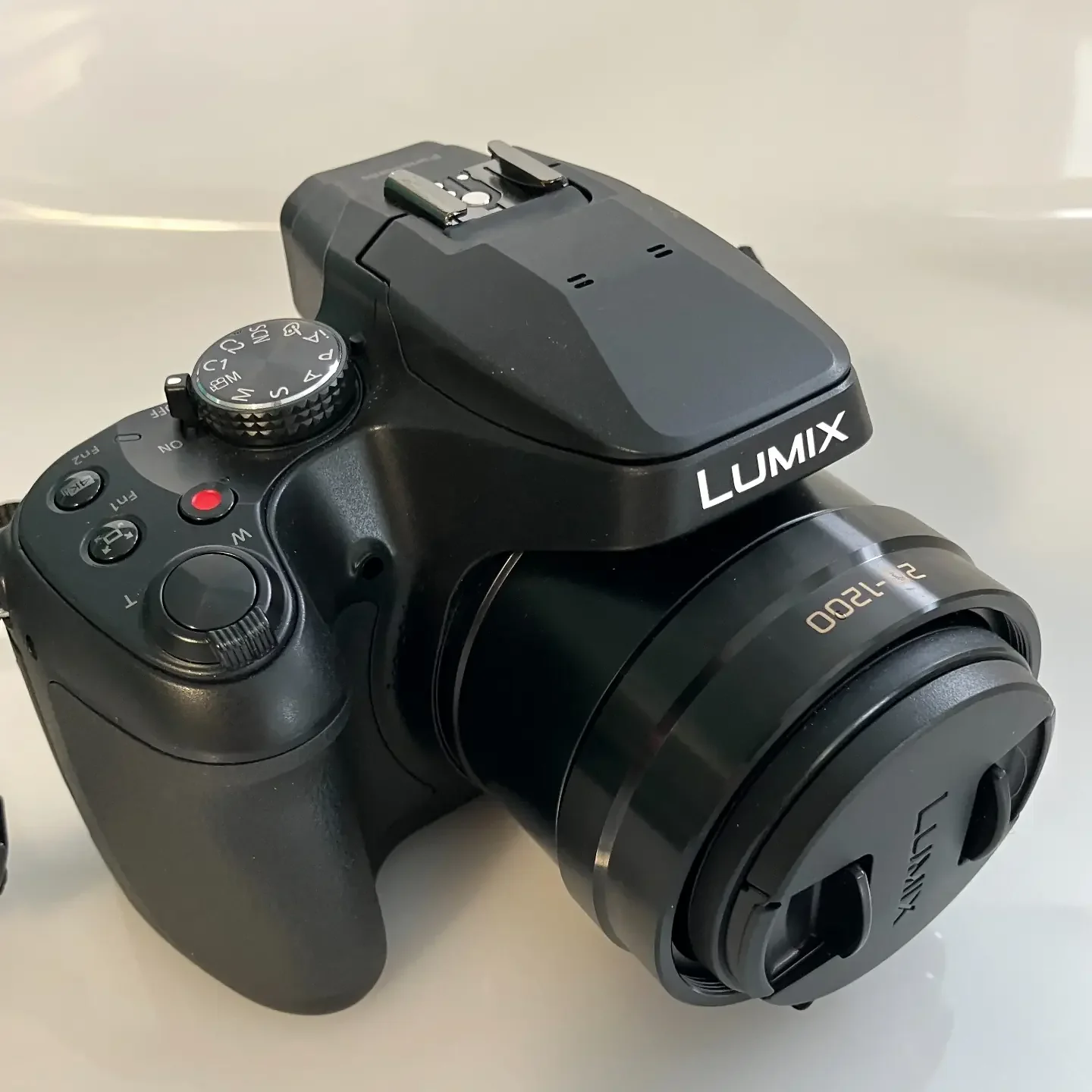 Panasonic Lumix FZ82D viewed from the front and above, with its lens cap fitted.