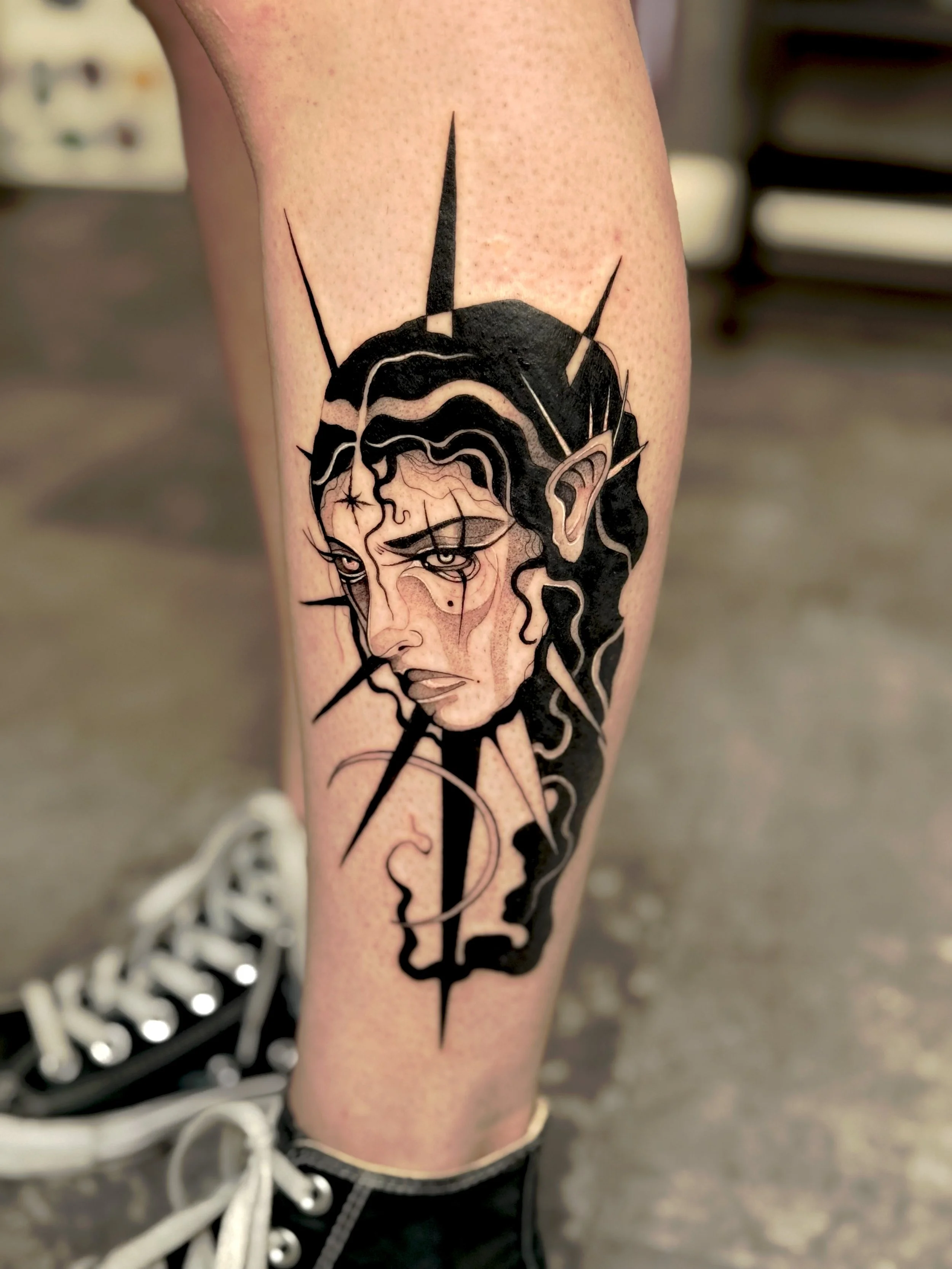 Tattoo van een vrouw met lang haar en een blik. Theoretisch zelfportret met lijnen en schaduw op bijna volledige arm