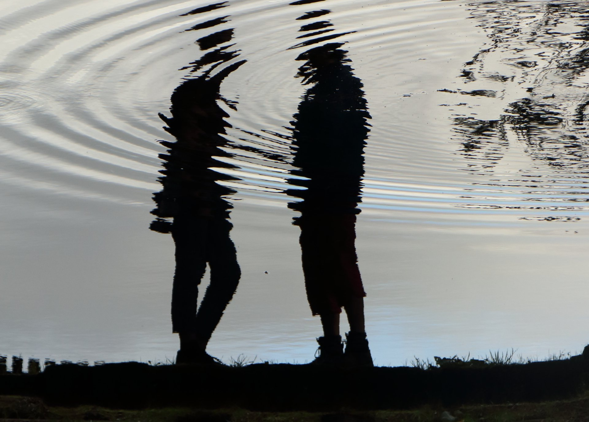 Reflections of people talking in rippled pond