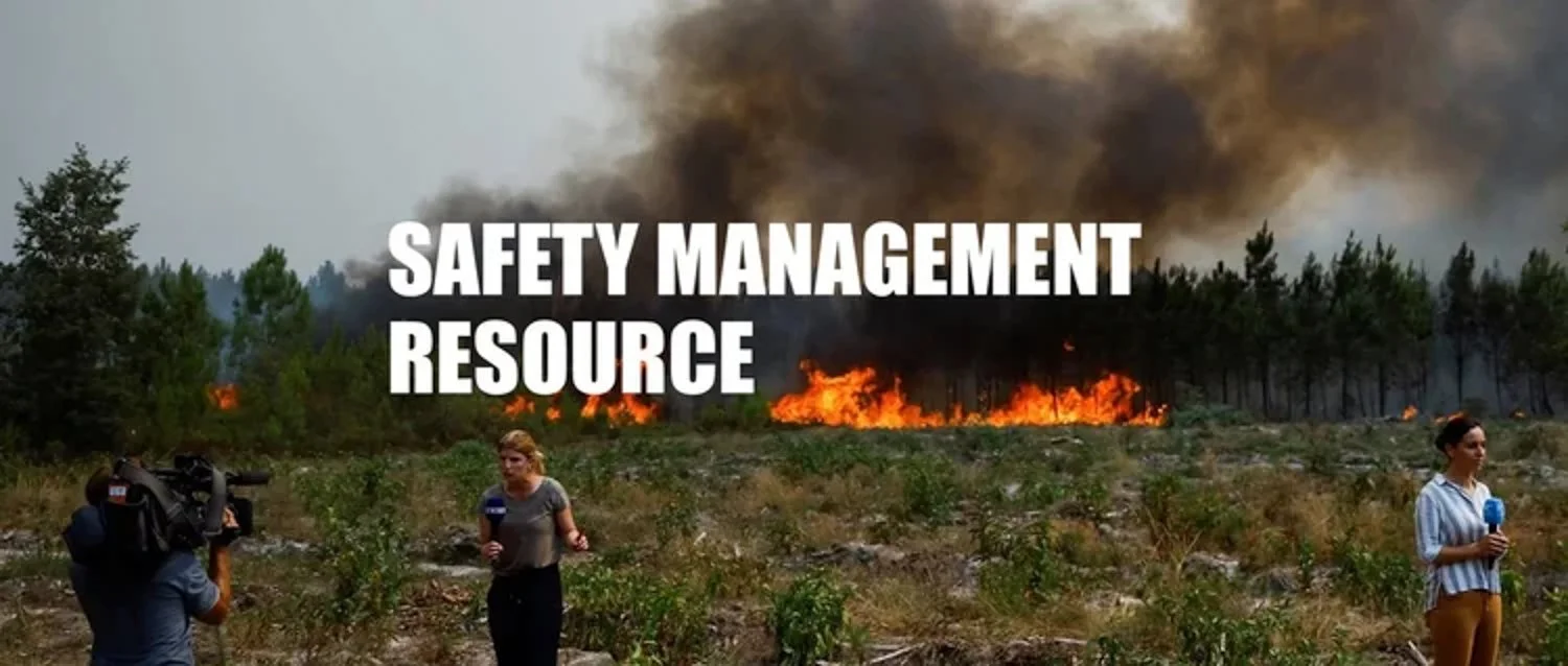 A news report with two reporters in a fire-damaged area, with a forest on fire and large smoke plumes in the background, overlaid with the text 'Safety Management Resource'.