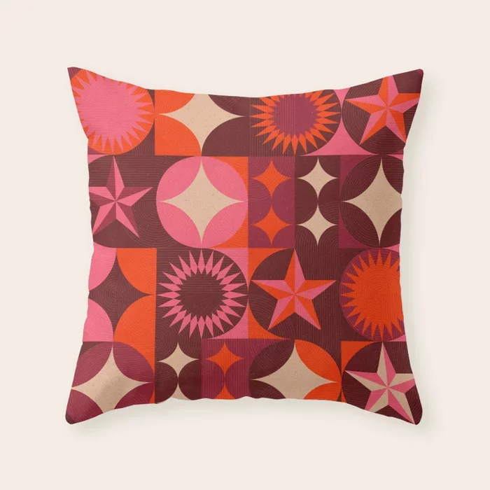 Society6 – Below the stars art print. Colourful decorative pillow with geometric starburst and circular patterns in pink, orange, red, and beige.