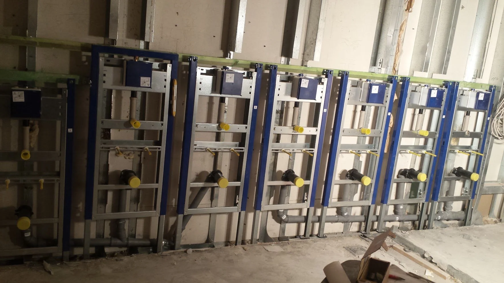 Installationsrahmen für Sanitärleitungen in einem Bauprojekt, noch unvollständig, mit Rohren und Verbindungsstücken.