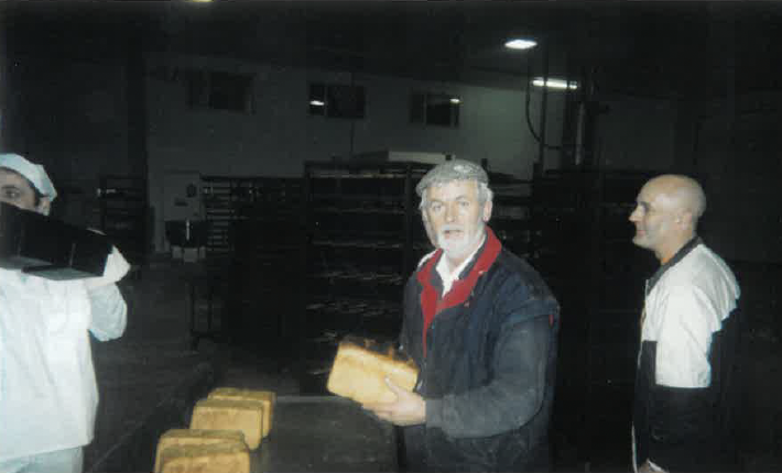 Historic photograph of bakery staff inspecting freshly baked loaves during the early years of O'Keeffe's Family Bakery.