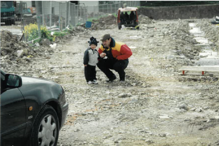 Historic photograph of a family member and child visiting the construction site of the new O'Keeffe's bakery.
