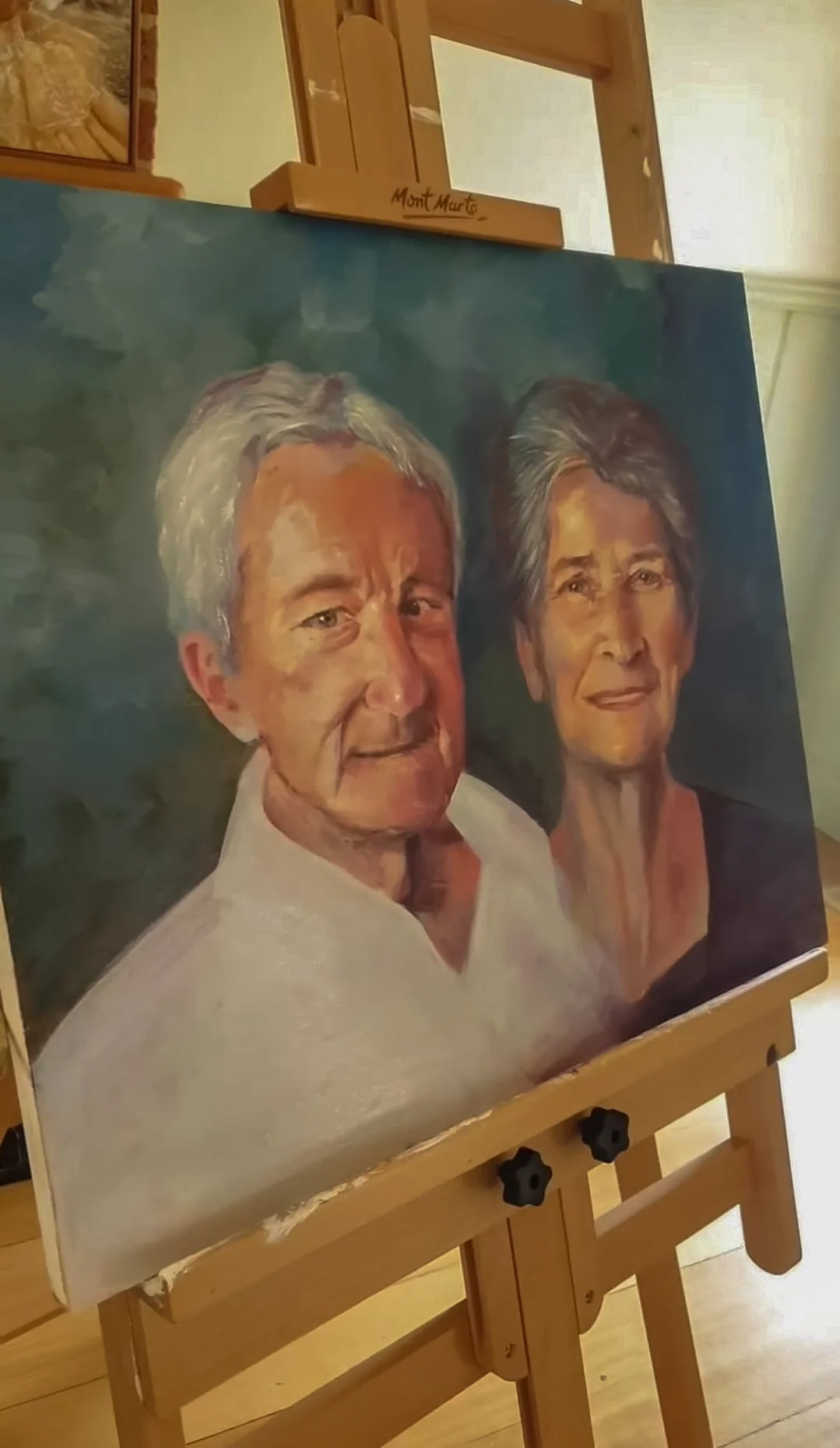 A painting of an elderly man and woman. The man has gray hair and is wearing a white shirt, and the woman has gray hair and is wearing a black top.