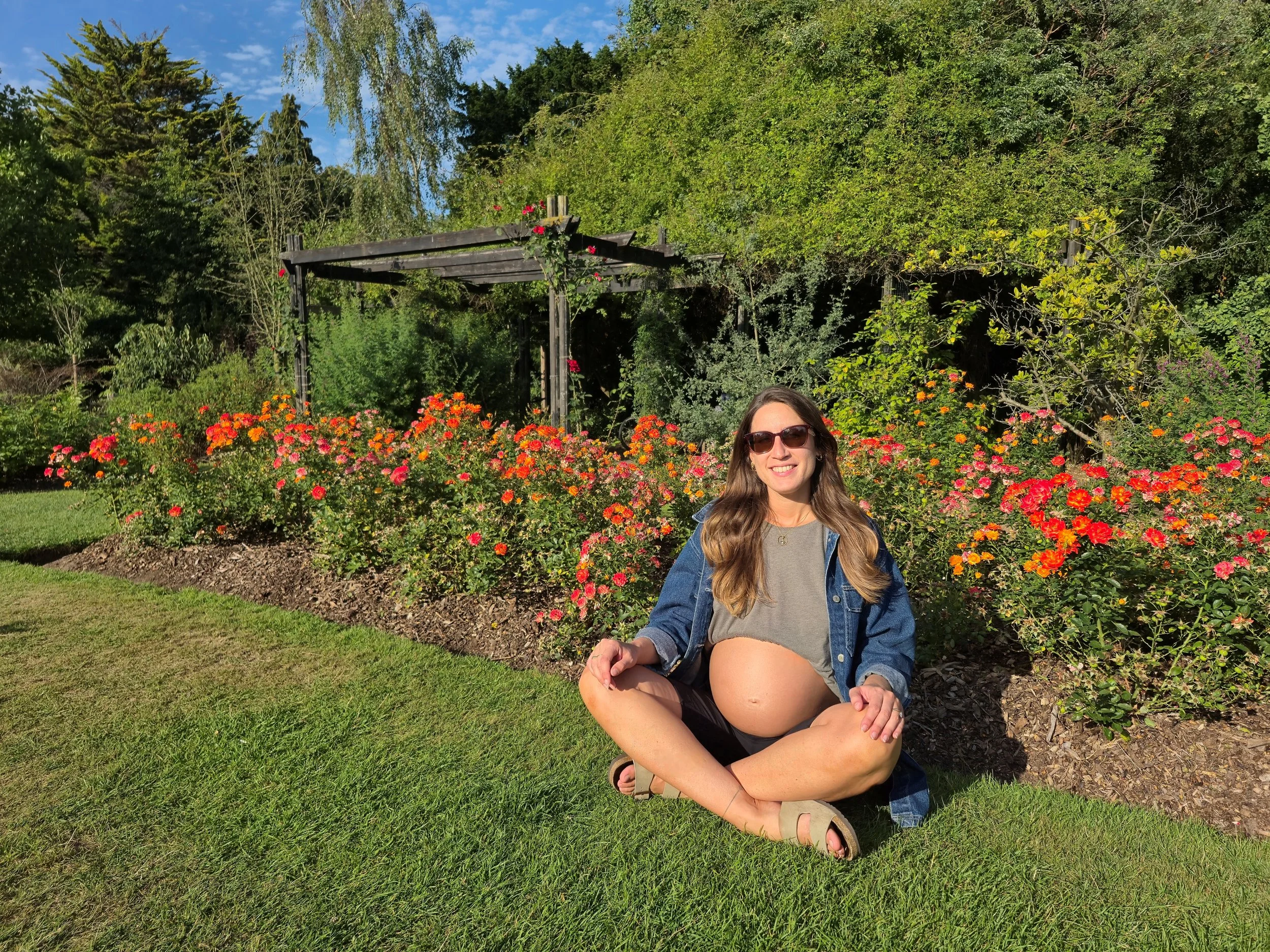 Rachele sitting cross-legged in a flower-filled park, practicing relaxation.
