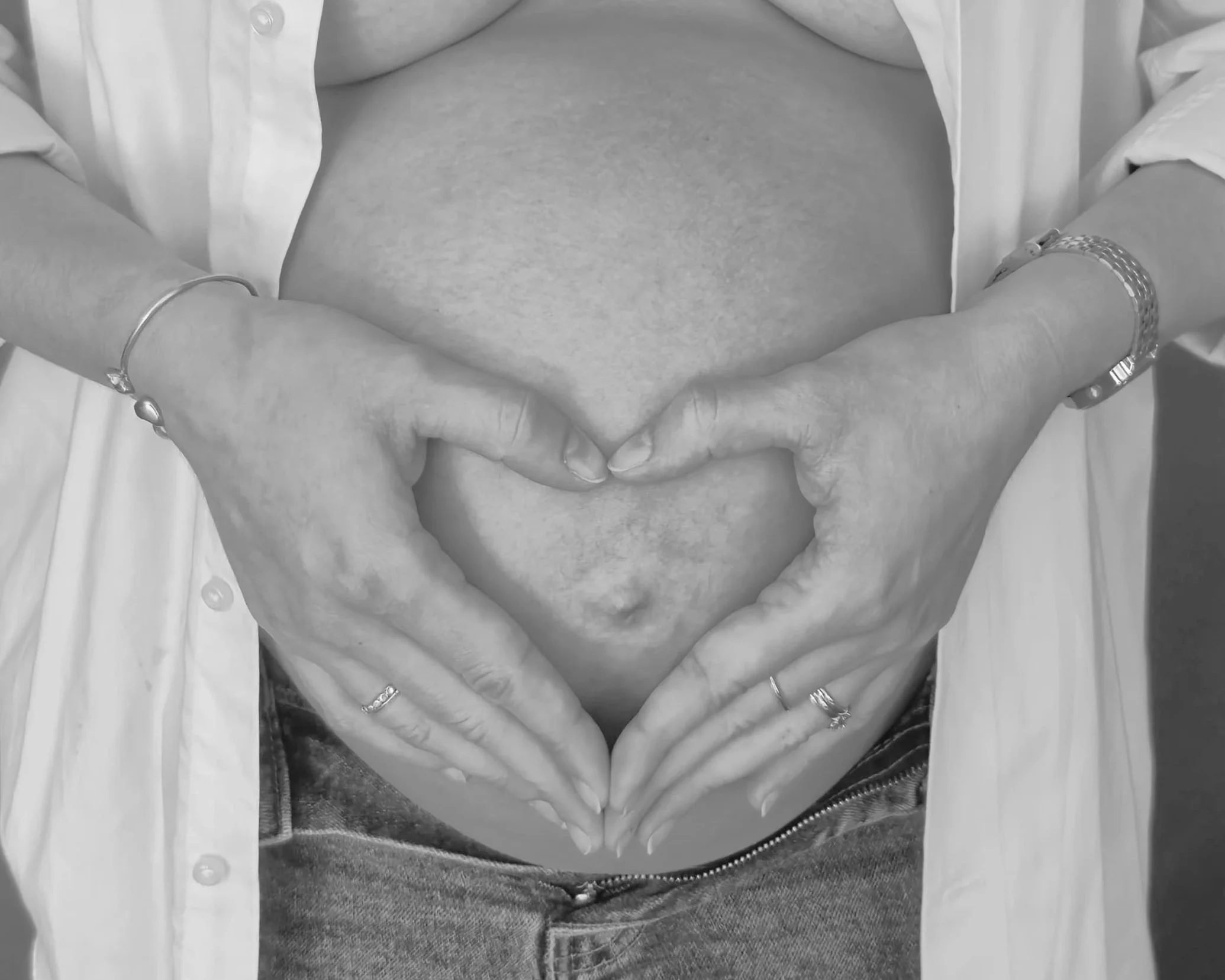 pregnant belly with heart hands 