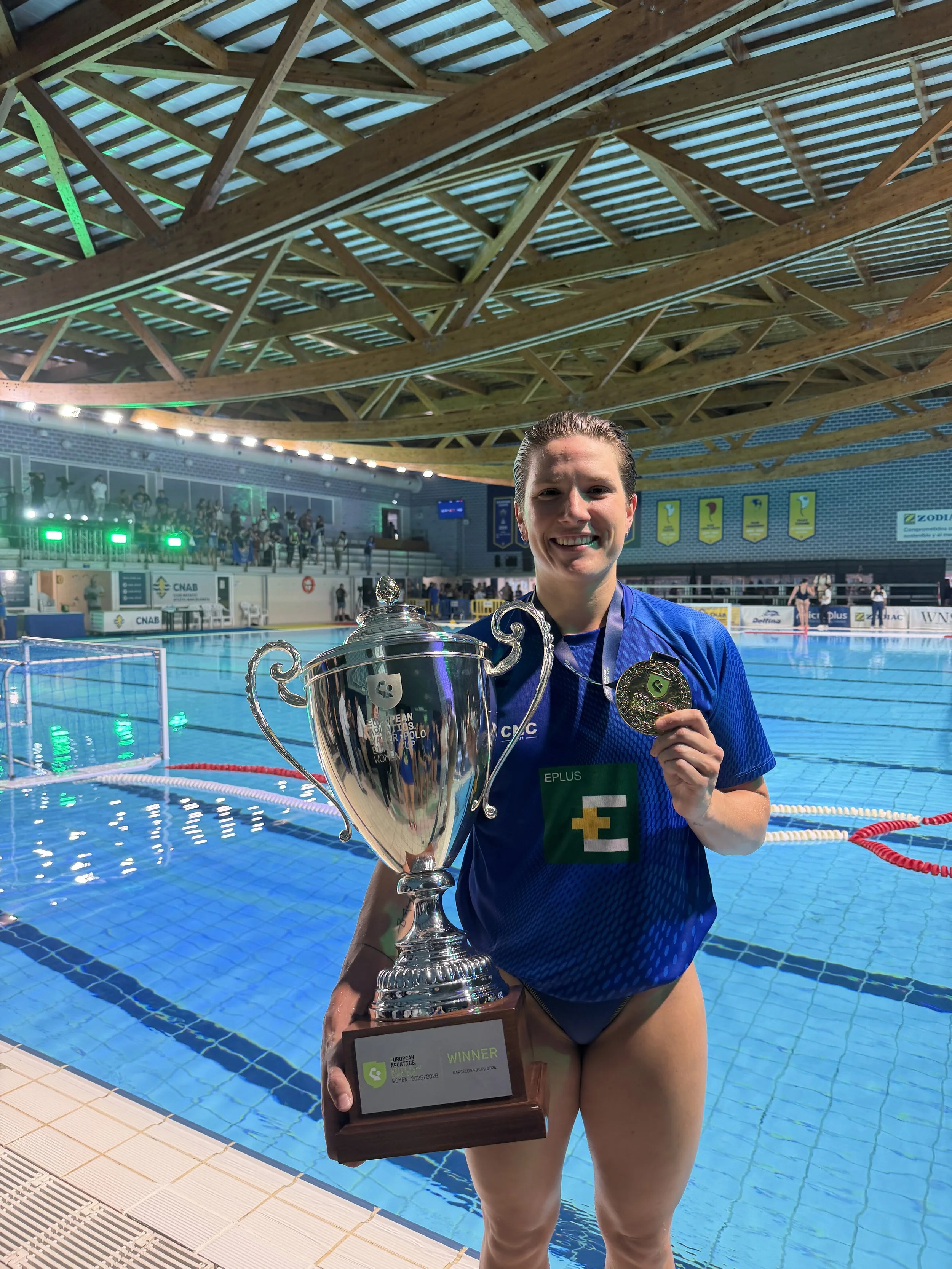 Laura Aarts standing with winning euro cup waterpolo trophy.