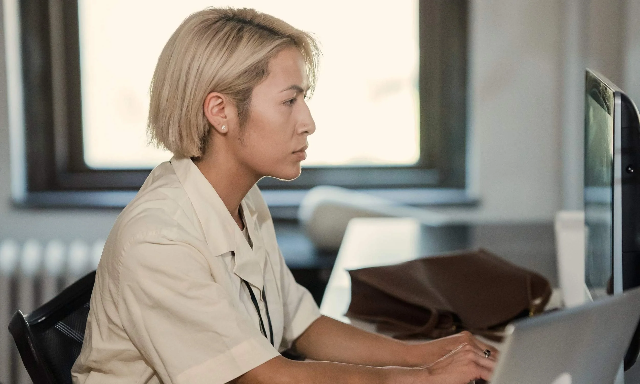 Professional working at a computer on resources supporting multiple chemical sensitivity research and education.