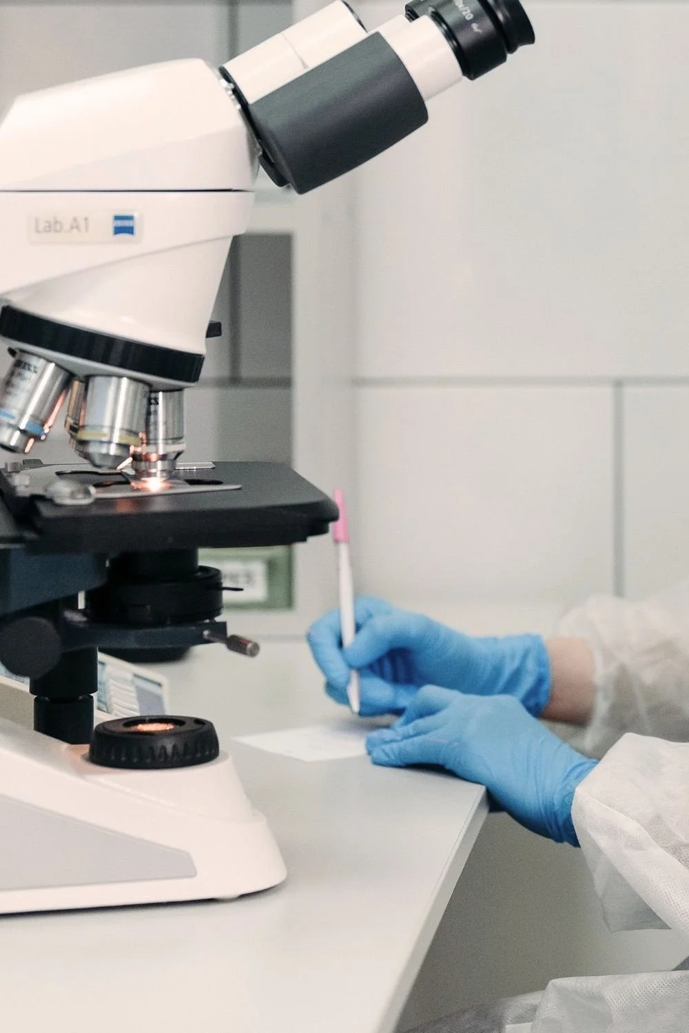 Laboratory microscope representing scientific research into multiple chemical sensitivity, potential treatments, and environmental health.