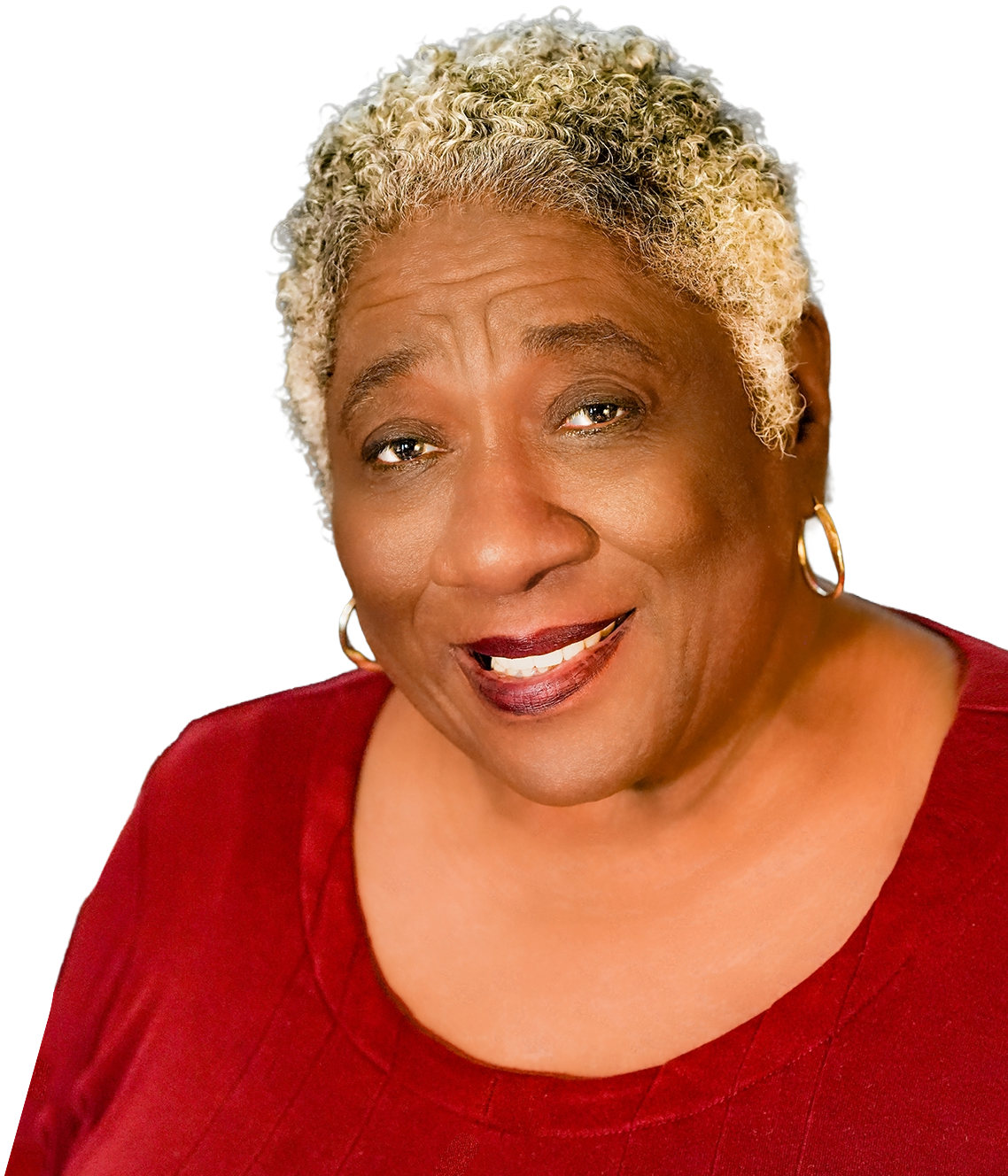 Joyce Randolph smiling in a red top and gold hoop earrings