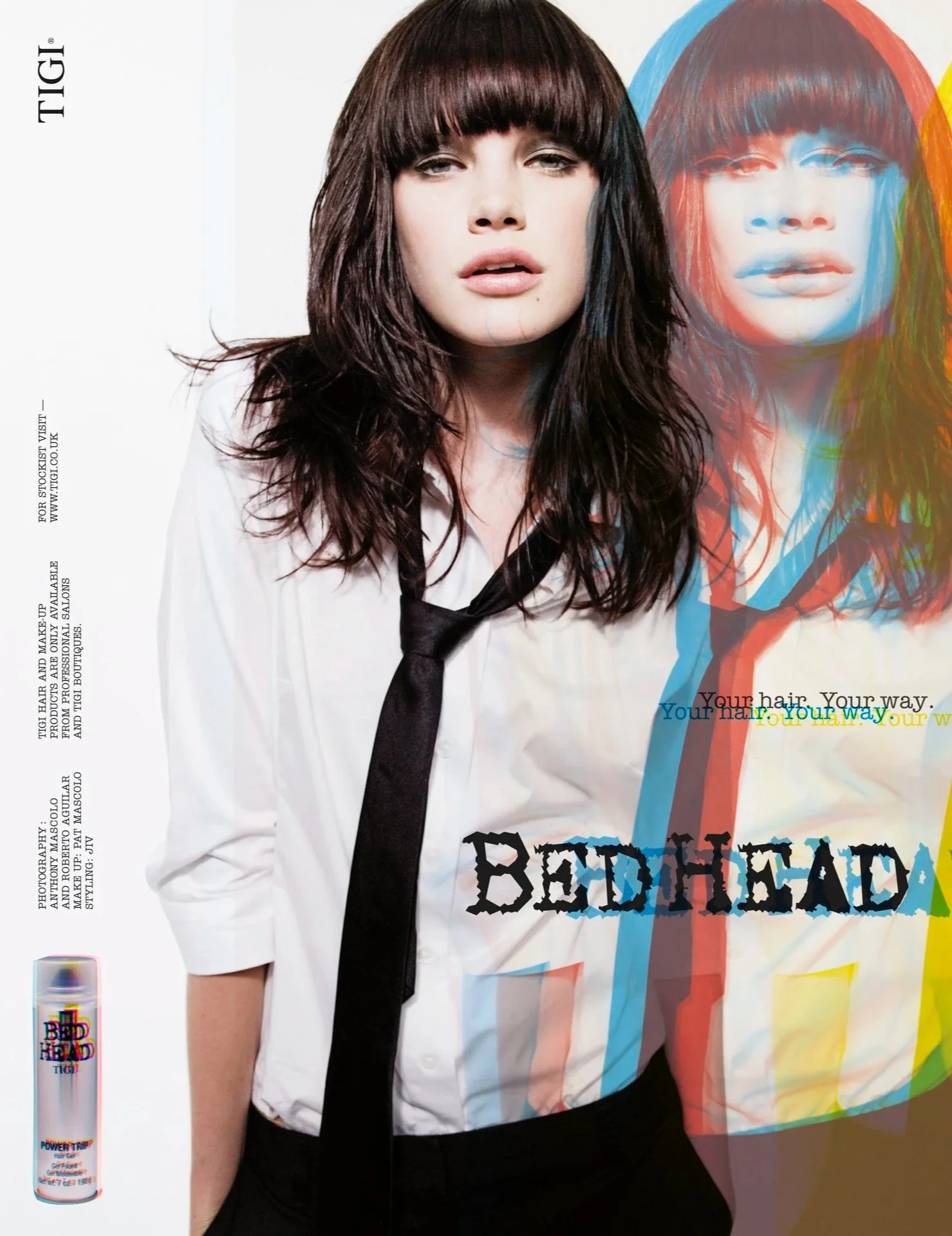 A woman with brown hair and bangs wearing a white shirt with a black tie, standing in front of a colorful background with a stylized image of herself. The word 'BEDHEAD' appears prominently on the image. There are additional text and design elements 