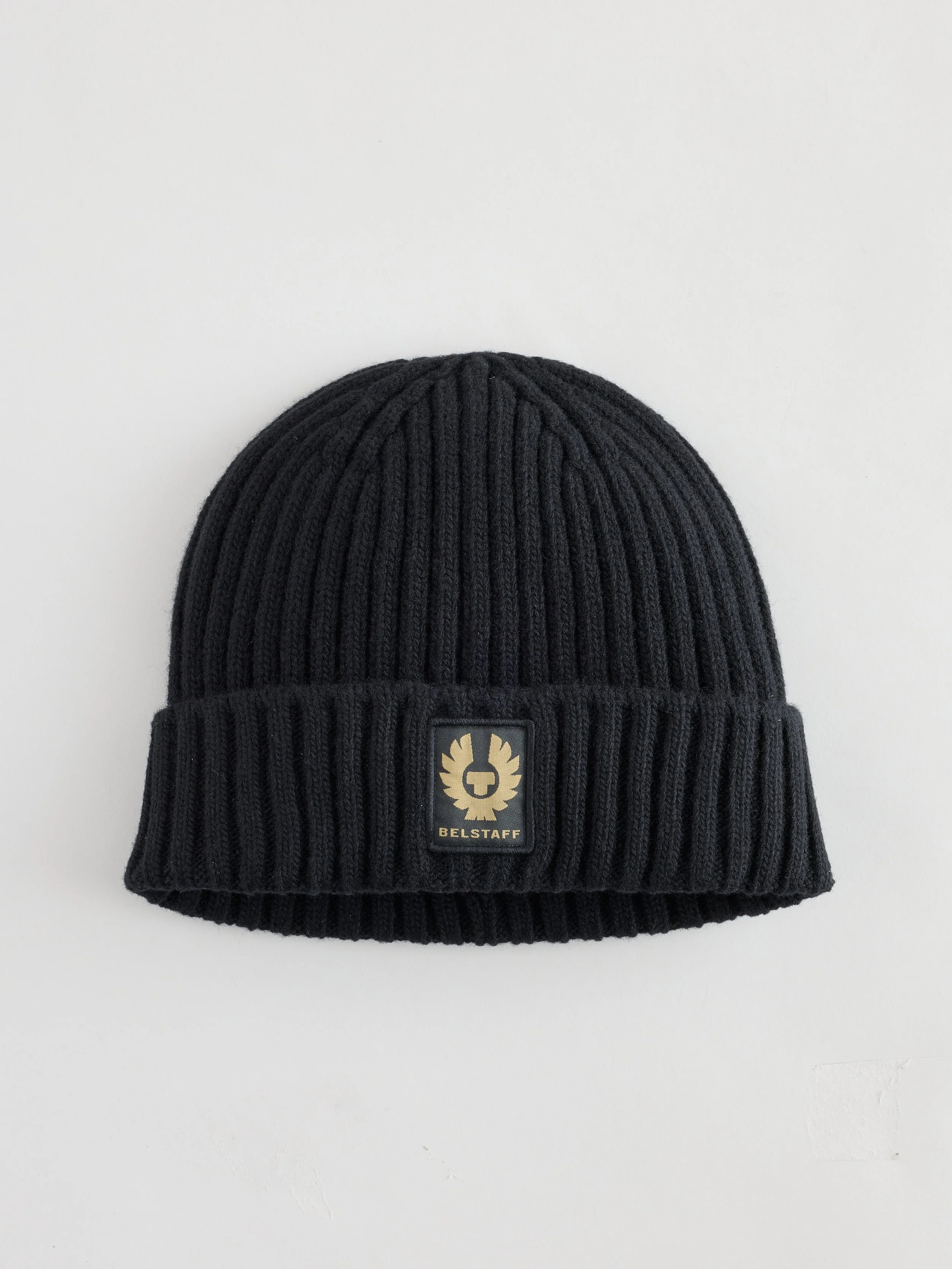 Black ribbed knit beanie with a leather patch featuring a lion's face and the text "BELSTAFF"