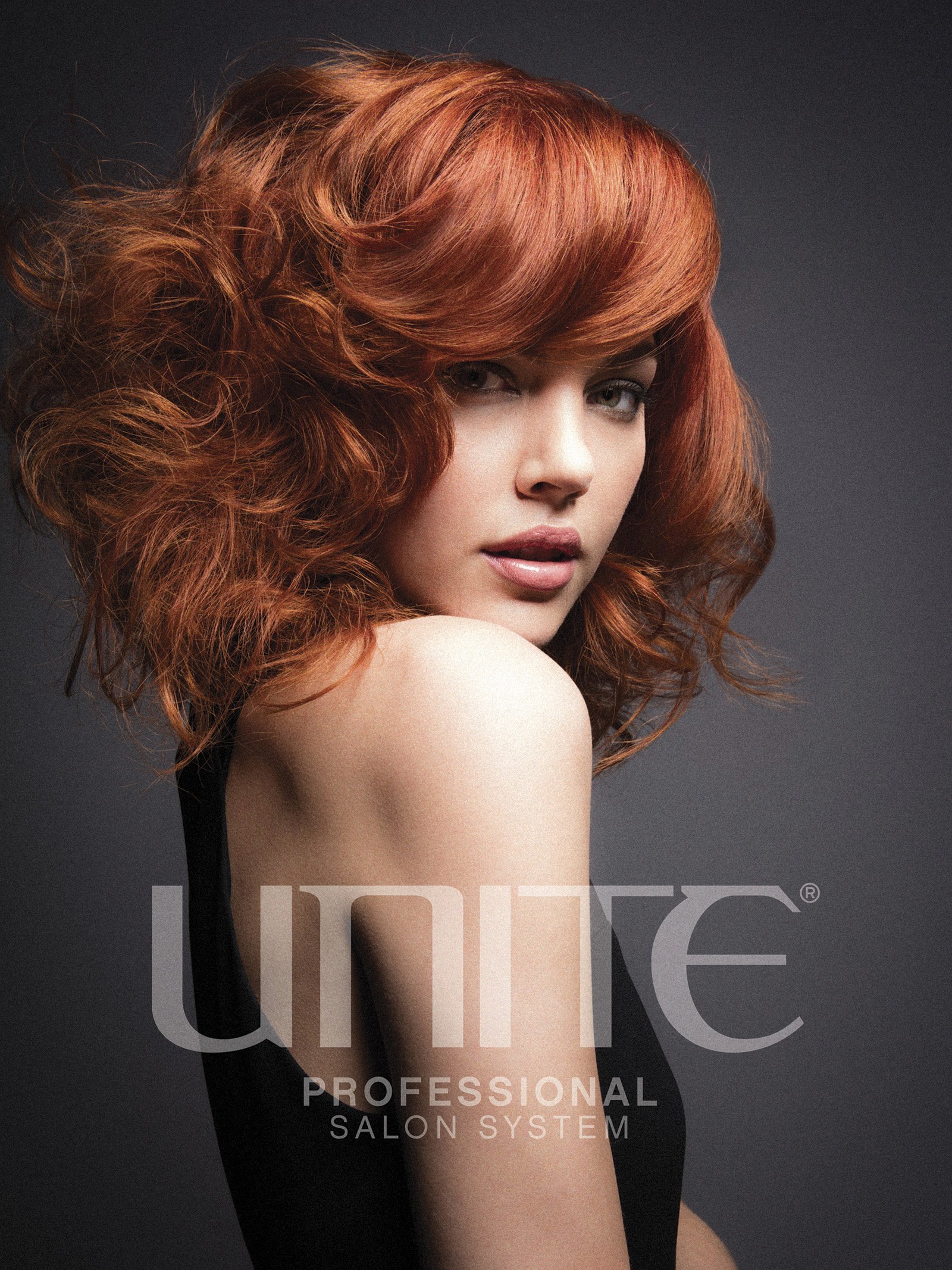 A woman with curly red hair in a salon advertisement.