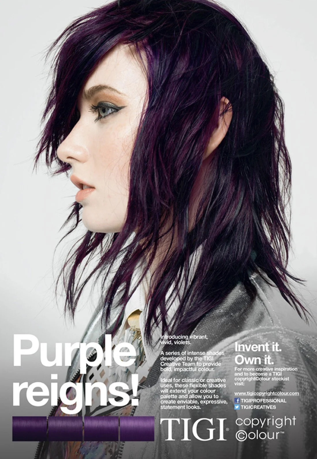 A woman with shoulder-length, layered violet hair posing in profile against a light background