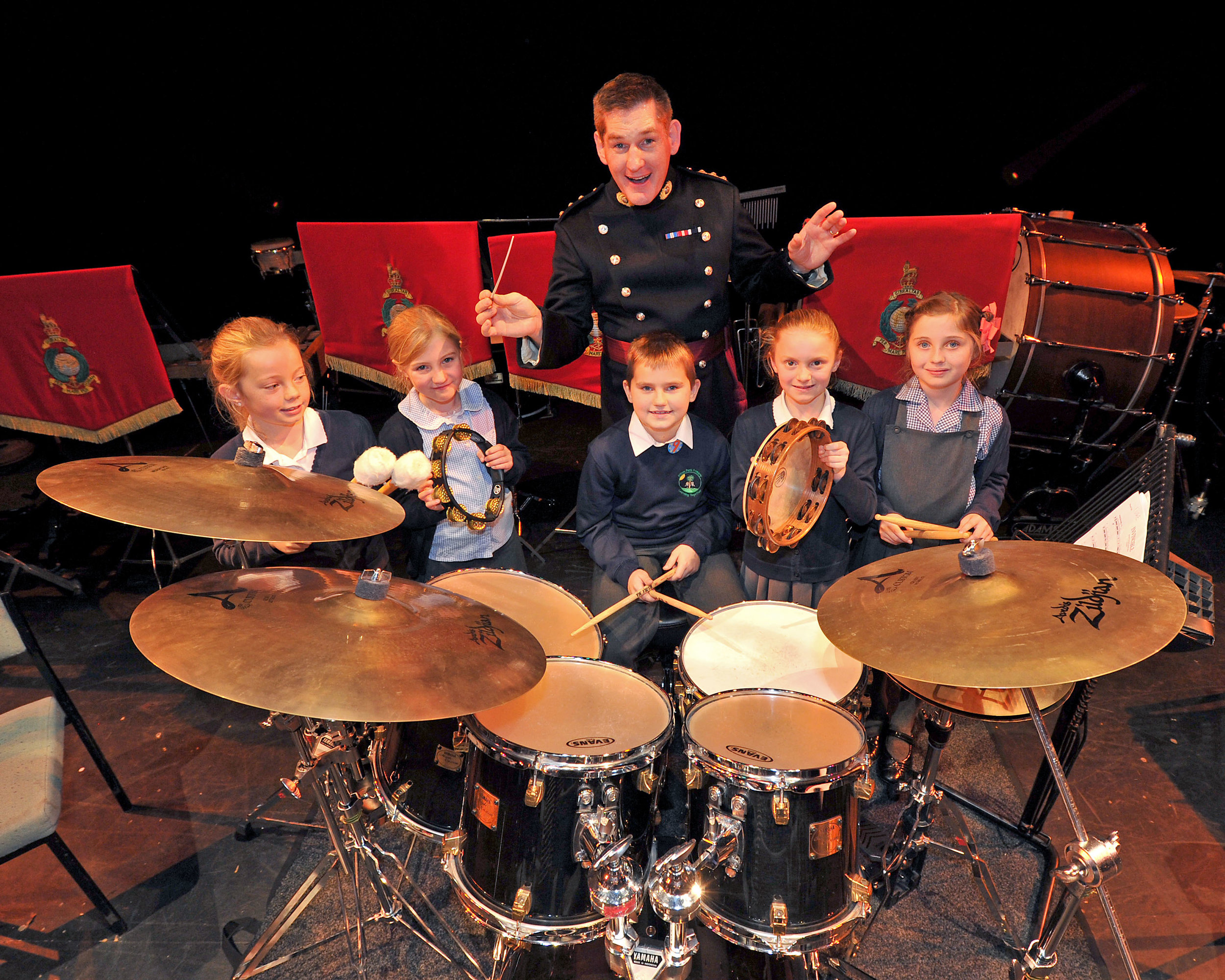 Local school children and Captain Andy Gregory RM from the Royal Marines Band Service