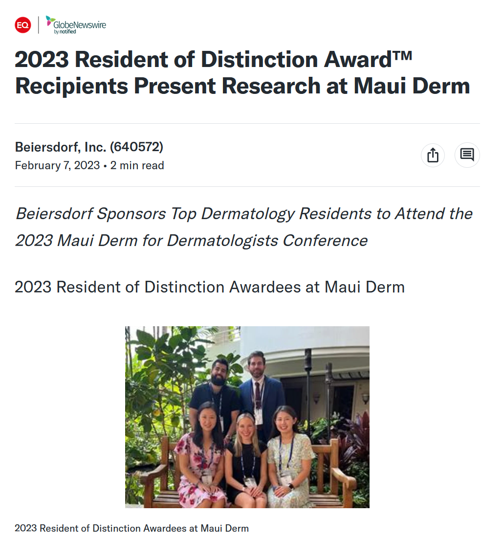 Group of five people, three women seated on a wooden bench and two men standing behind them, inside a lush, green indoor garden area, attending an award event at Maui Derm.
