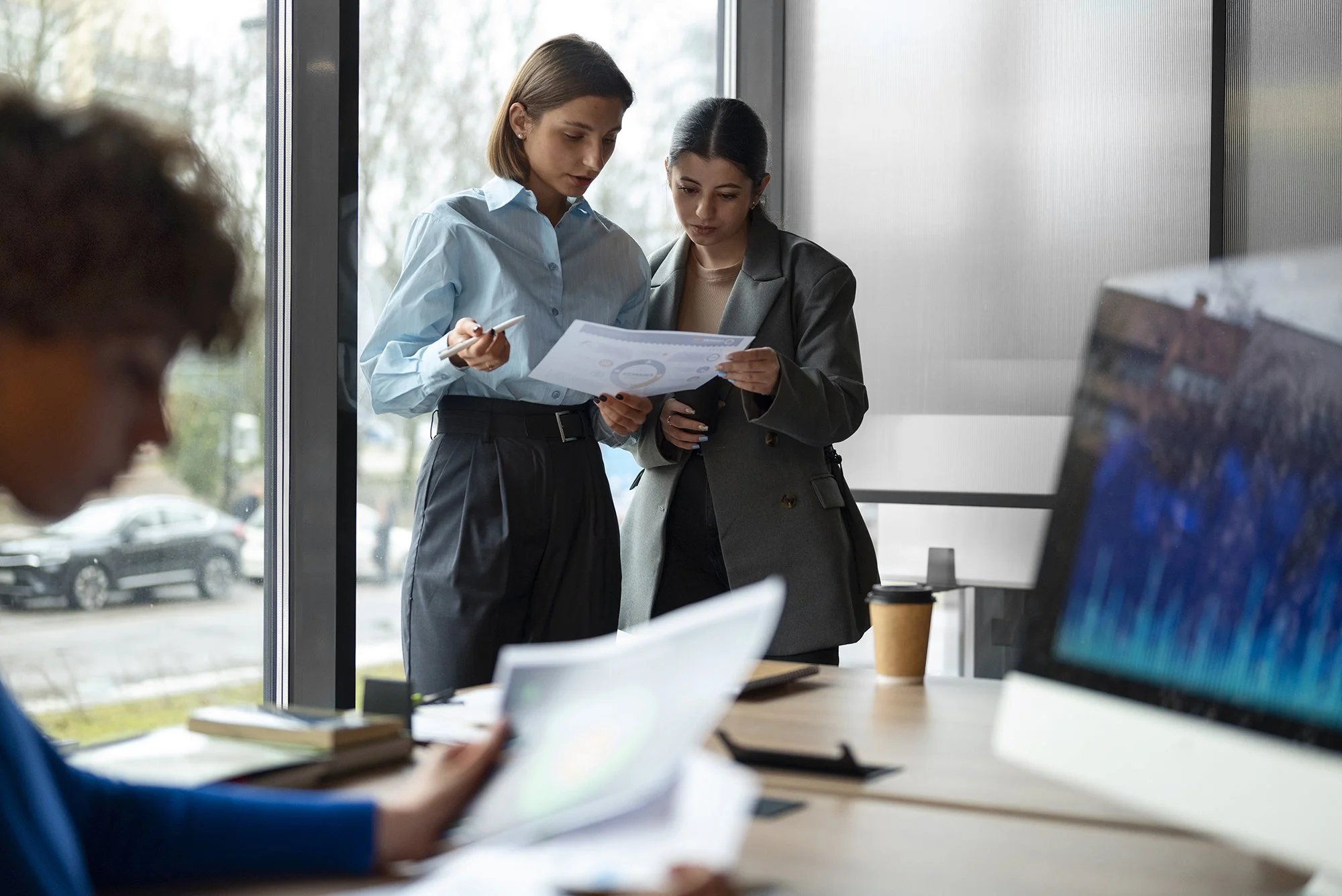 Coppia di donne che lavorano in azienda e stanno controllando dei fogli