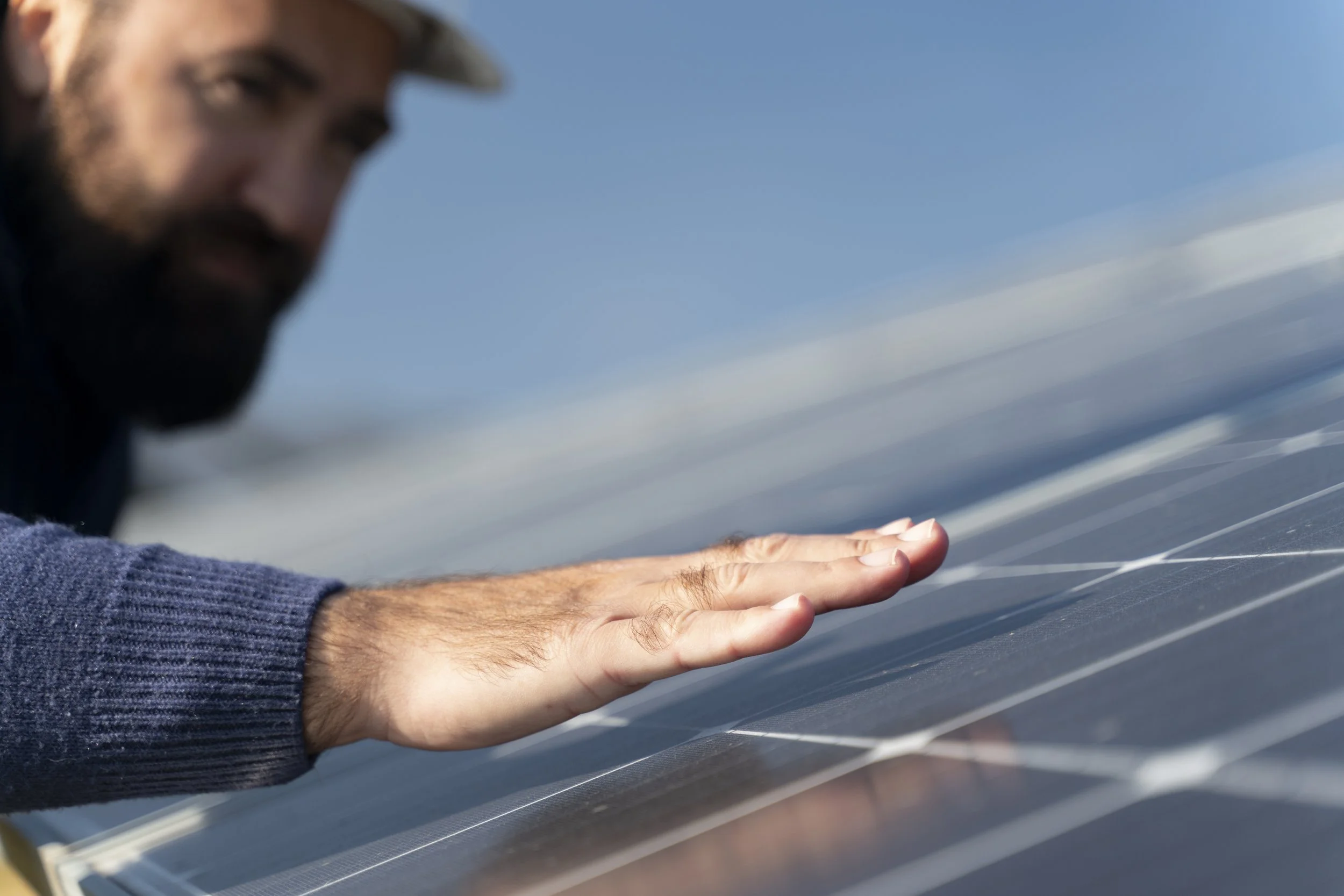 Uomo che controlla un pannello solare con le mani