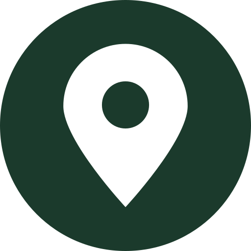 A black map pin icon inside a dark green circle, representing location or place.